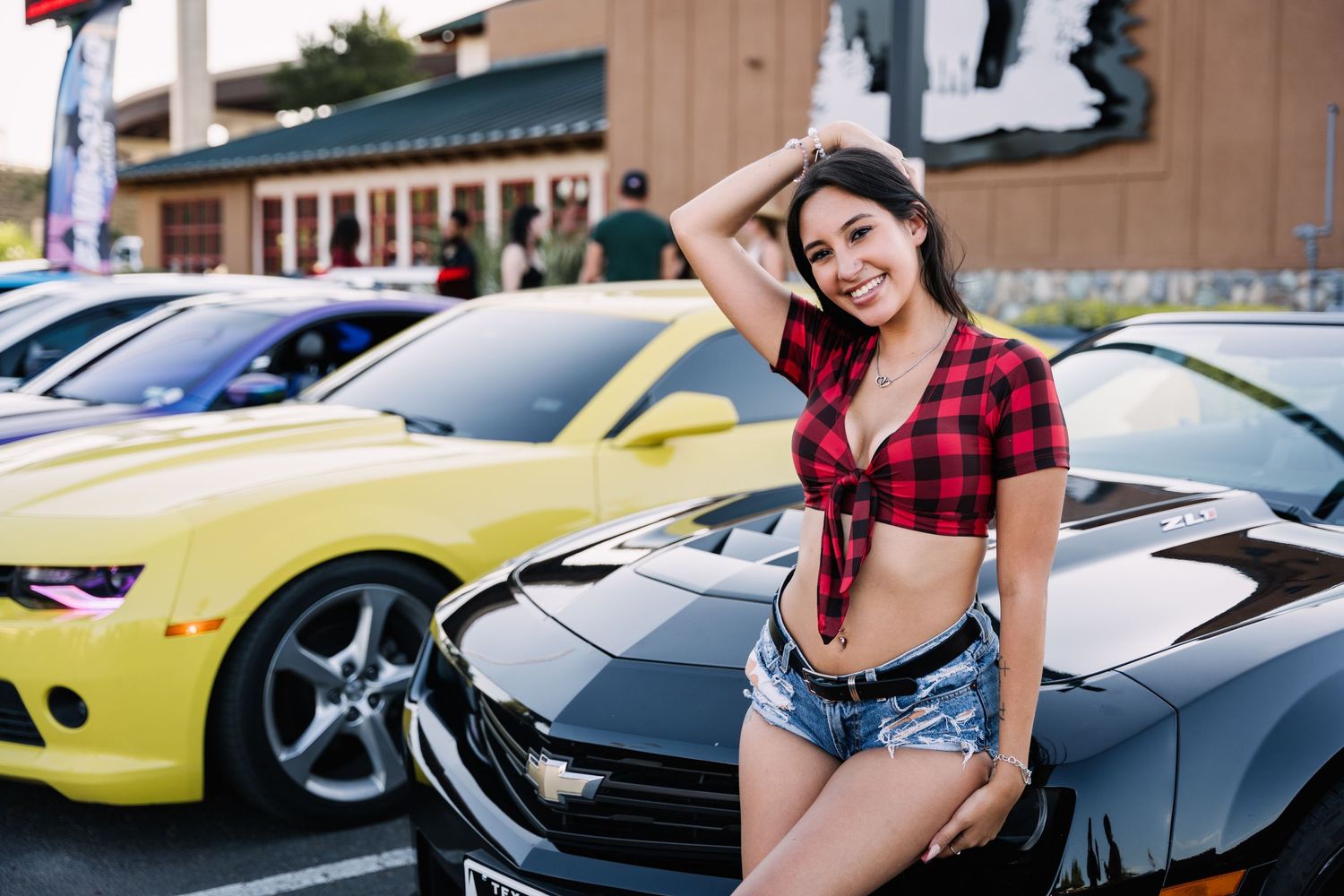 Car show event featuring customized vehicles on display in a parking lot.