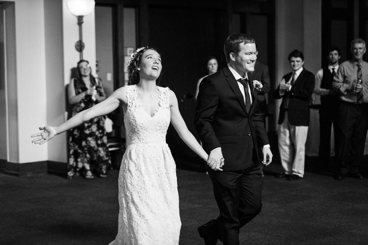 A joyful moment captured in black and white as newlyweds celebrate at their reception.