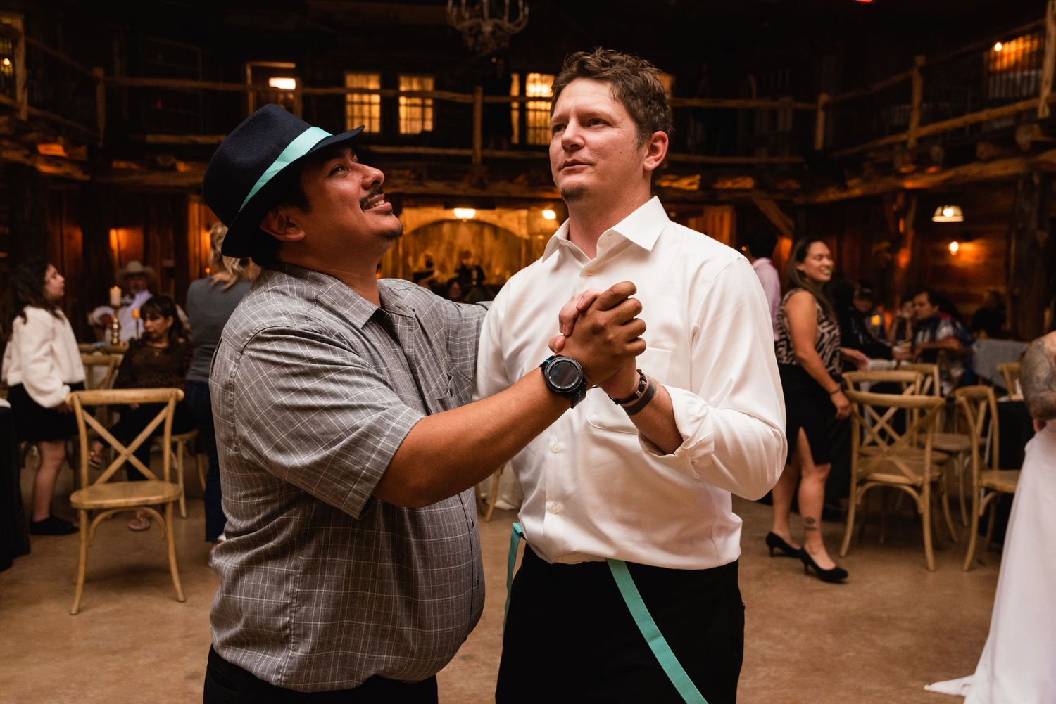 Two guests demonstrating dance moves on the rustic barn reception floor.