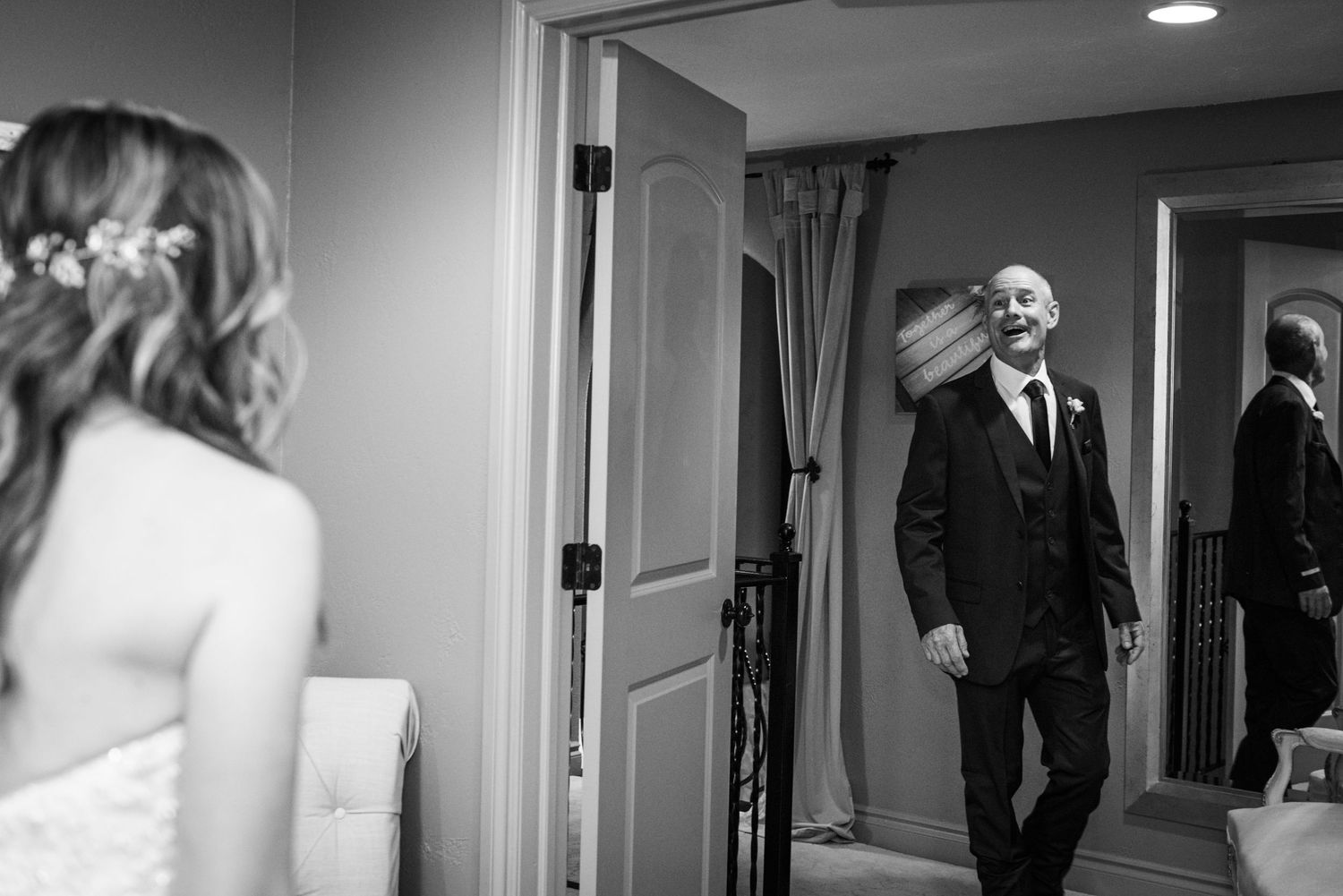 A tender black and white moment captured through an interior doorway.