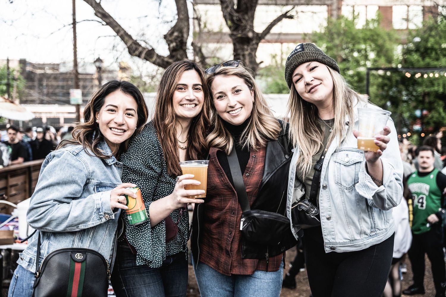 Friends enjoying drinks and socializing at outdoor festival gathering.
