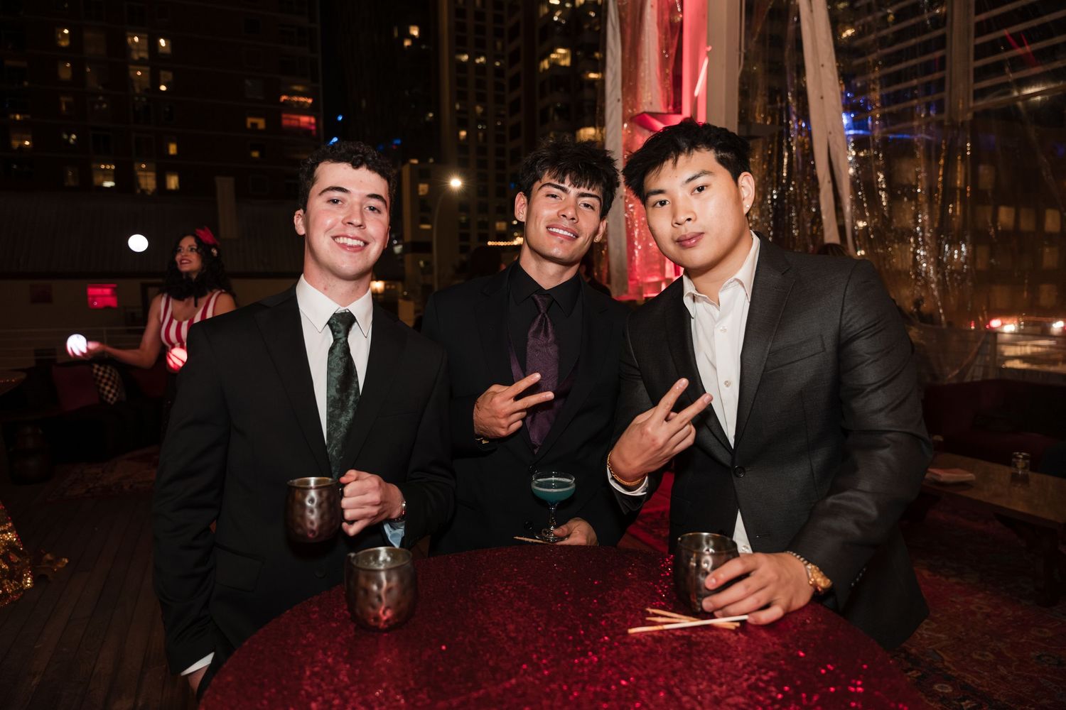 A group of people in formal attire posing together at a nighttime event.