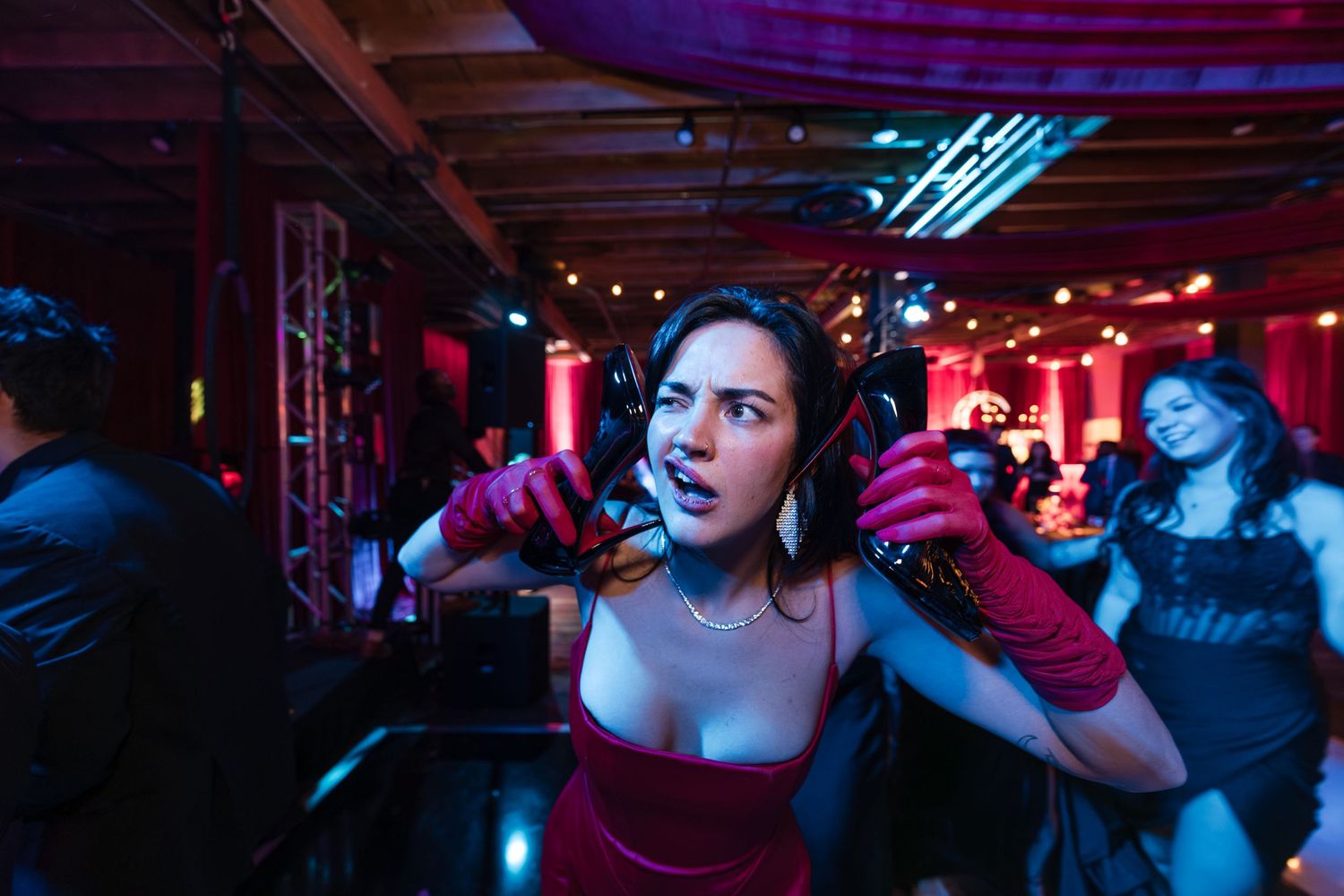 People dancing in a dimly lit nightclub with colorful blue and red lighting creating an energetic atmosphere.
