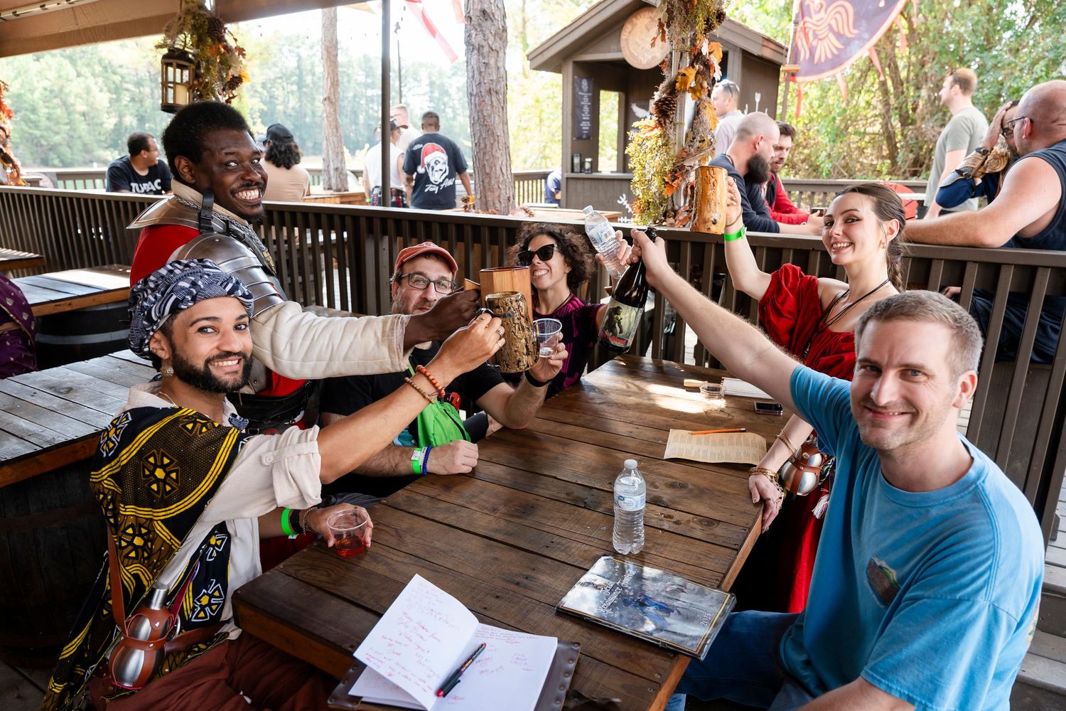 Friends enjoying drinks and conversation at an outdoor patio table during a casual gathering.