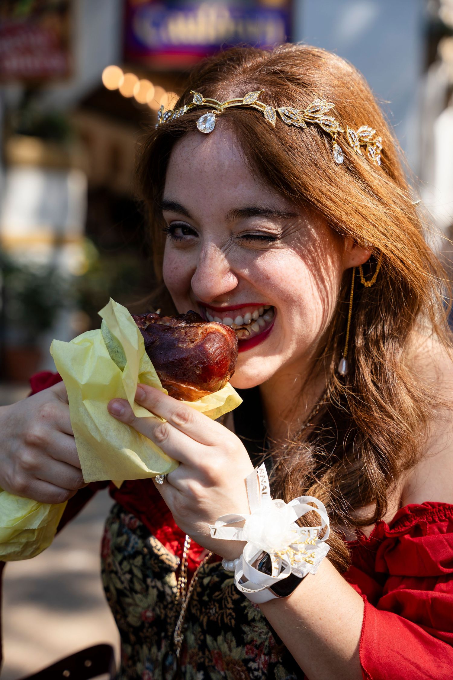 A series of photos showing someone in a red sweater taking bites of a sandwich with lettuce.