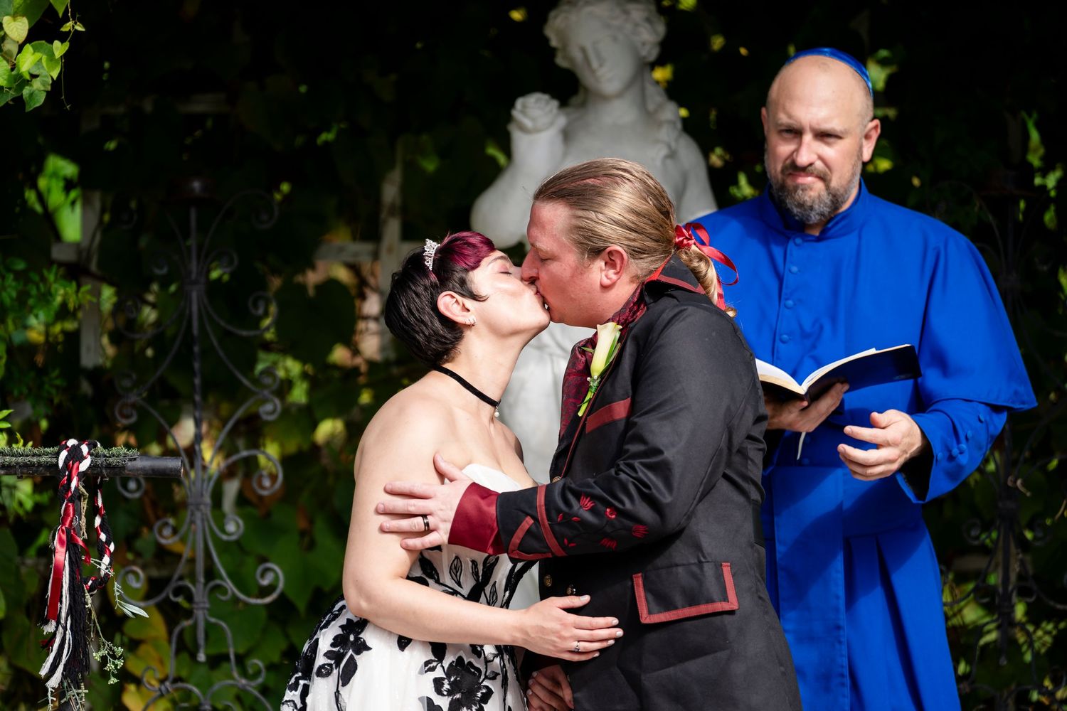 A couple embraces in a tender moment outdoors while wearing casual attire with bikes visible in the background.