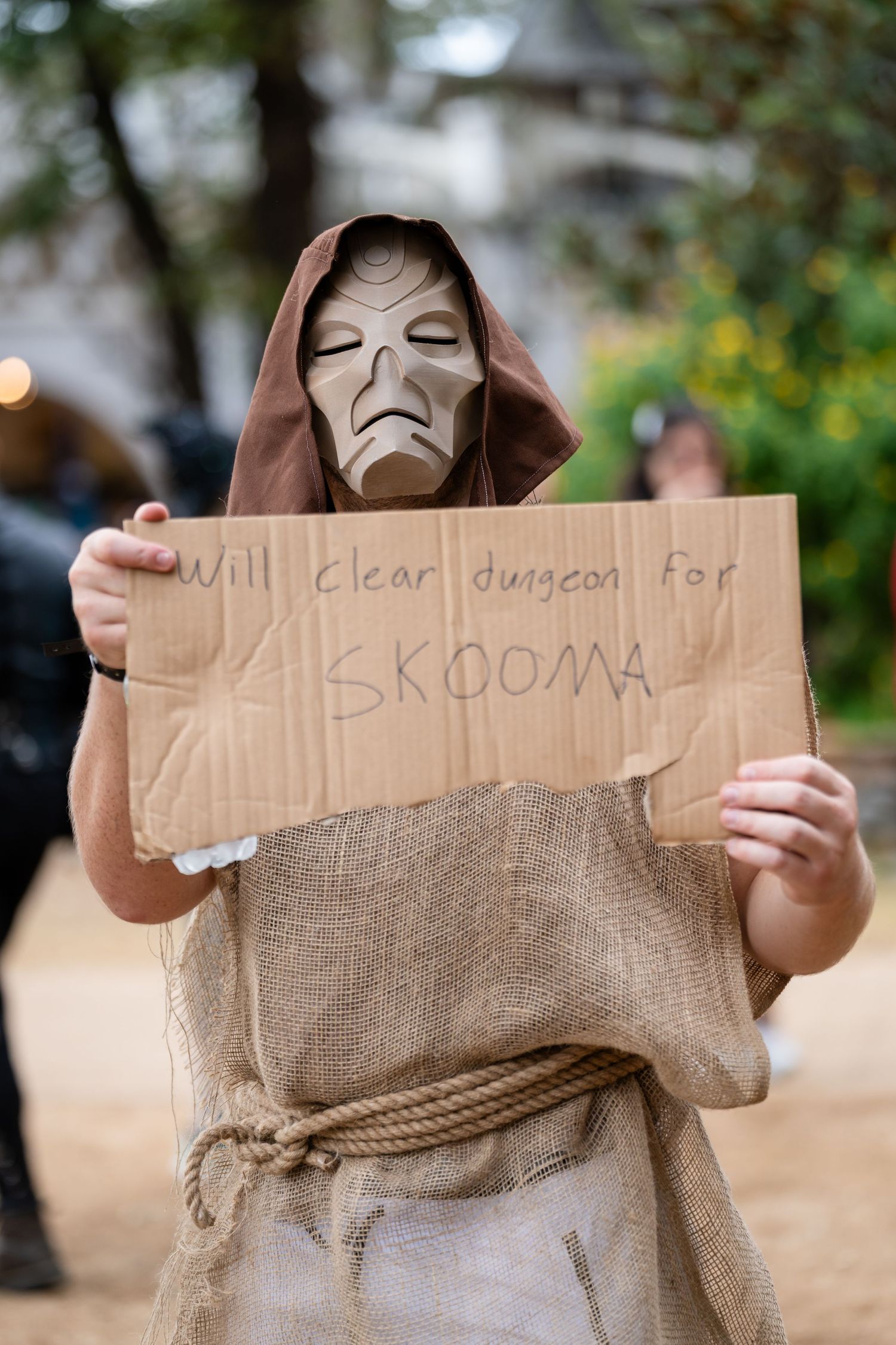 Four sequential photos show someone holding up a cardboard sign with a burlap sack covering their face.