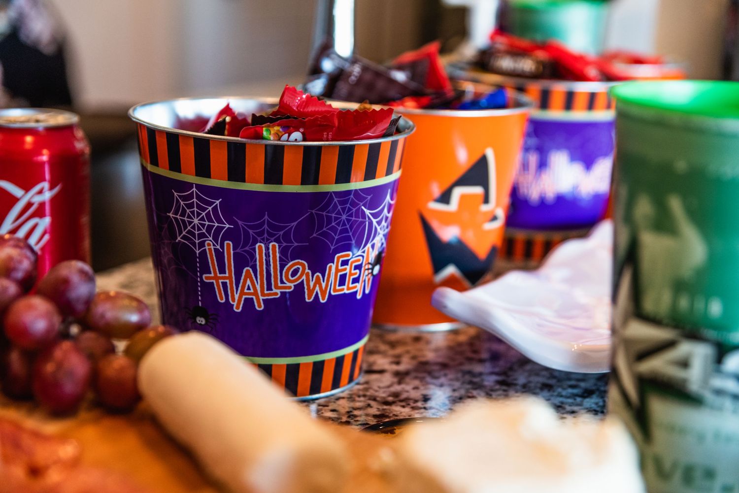 Colorful Halloween-themed party cups with orange and purple stripes arranged on a table.