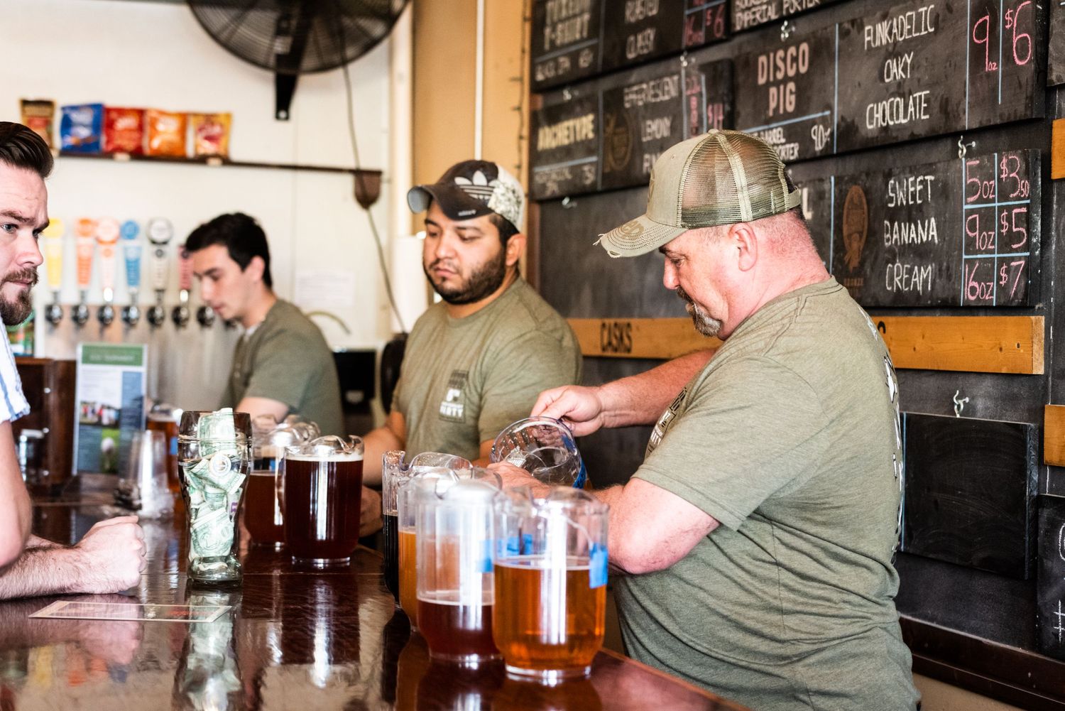 Selection of craft beers being served at brewery bar counter.