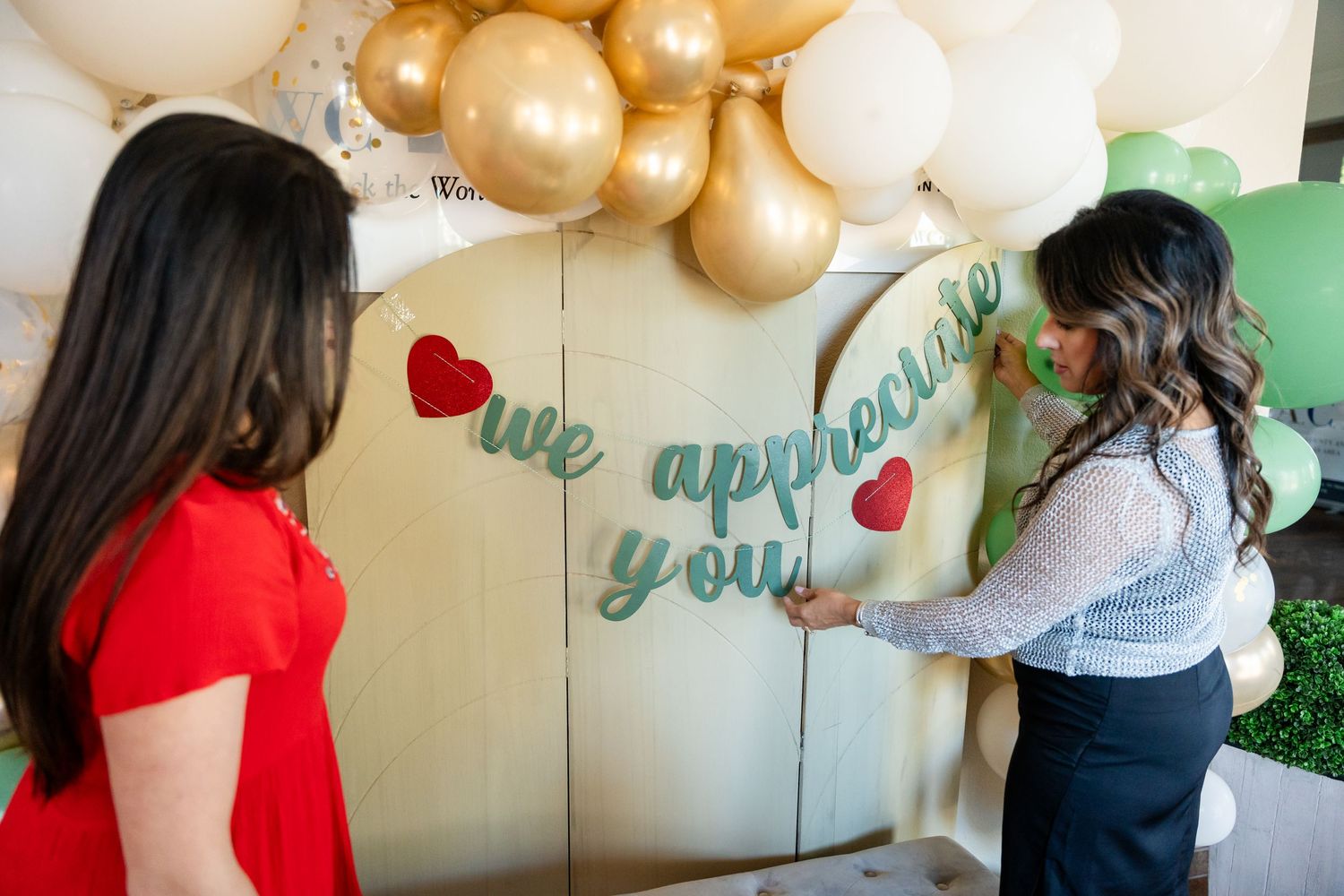 A balloon arch installation with 'we appreciate you' text on a wall.