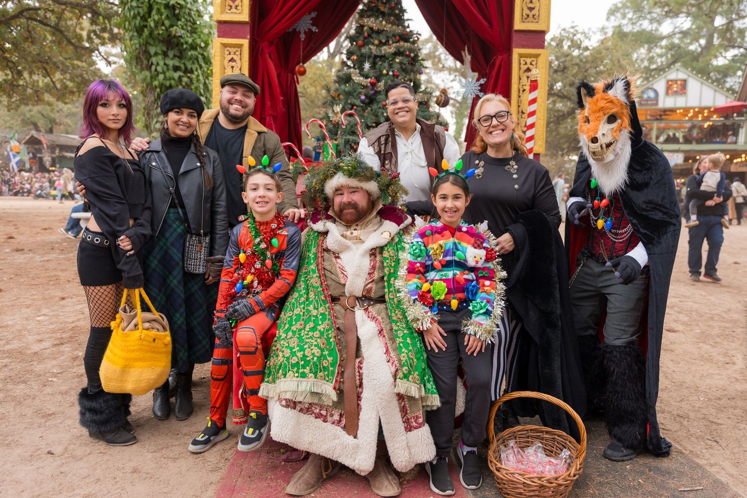 Group photo of festival attendees in colorful costumes and fantasy outfits posing together.