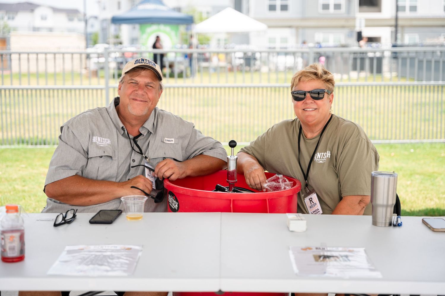 Two volunteers sitting at a registration table at an outdoor event.