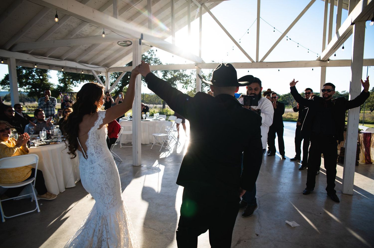 Wedding guests celebrating and dancing together under a covered outdoor venue.