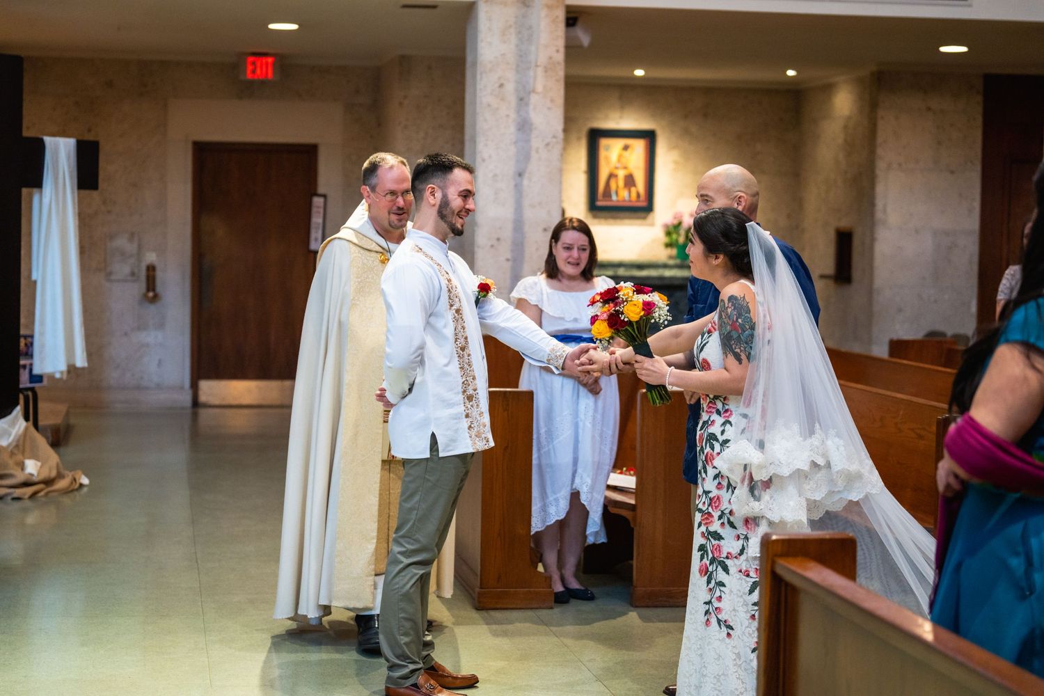 Wedding ceremony in progress with clergy and couple at altar in modern church interior.