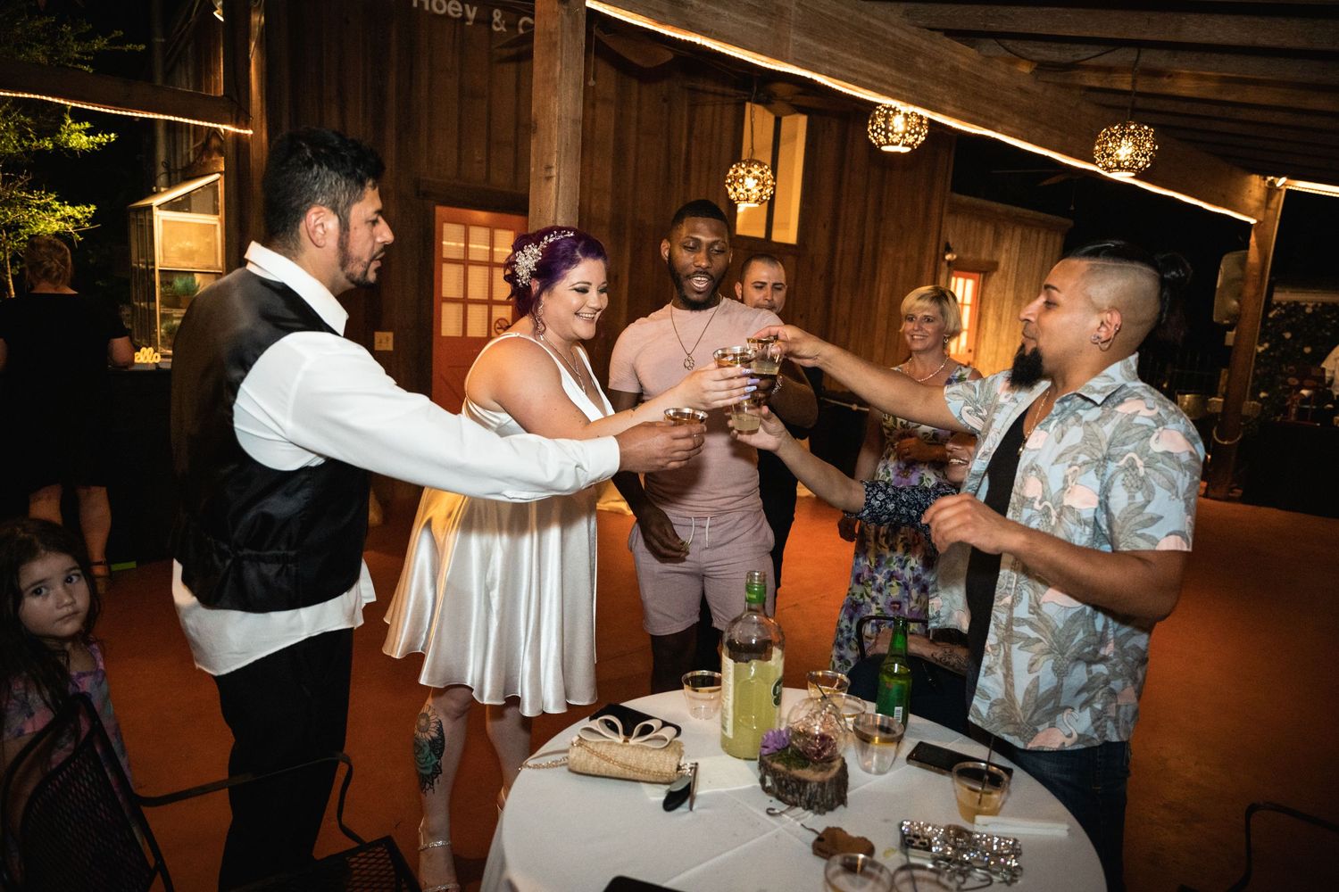 Party guests gather around a reception table for a celebratory toast.