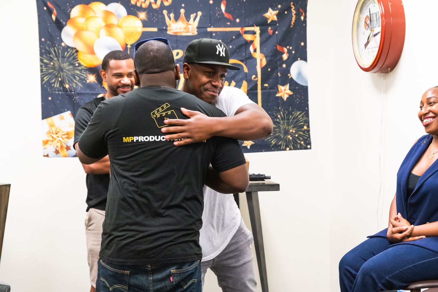 Two people share an embrace during what appears to be a celebratory moment indoors.