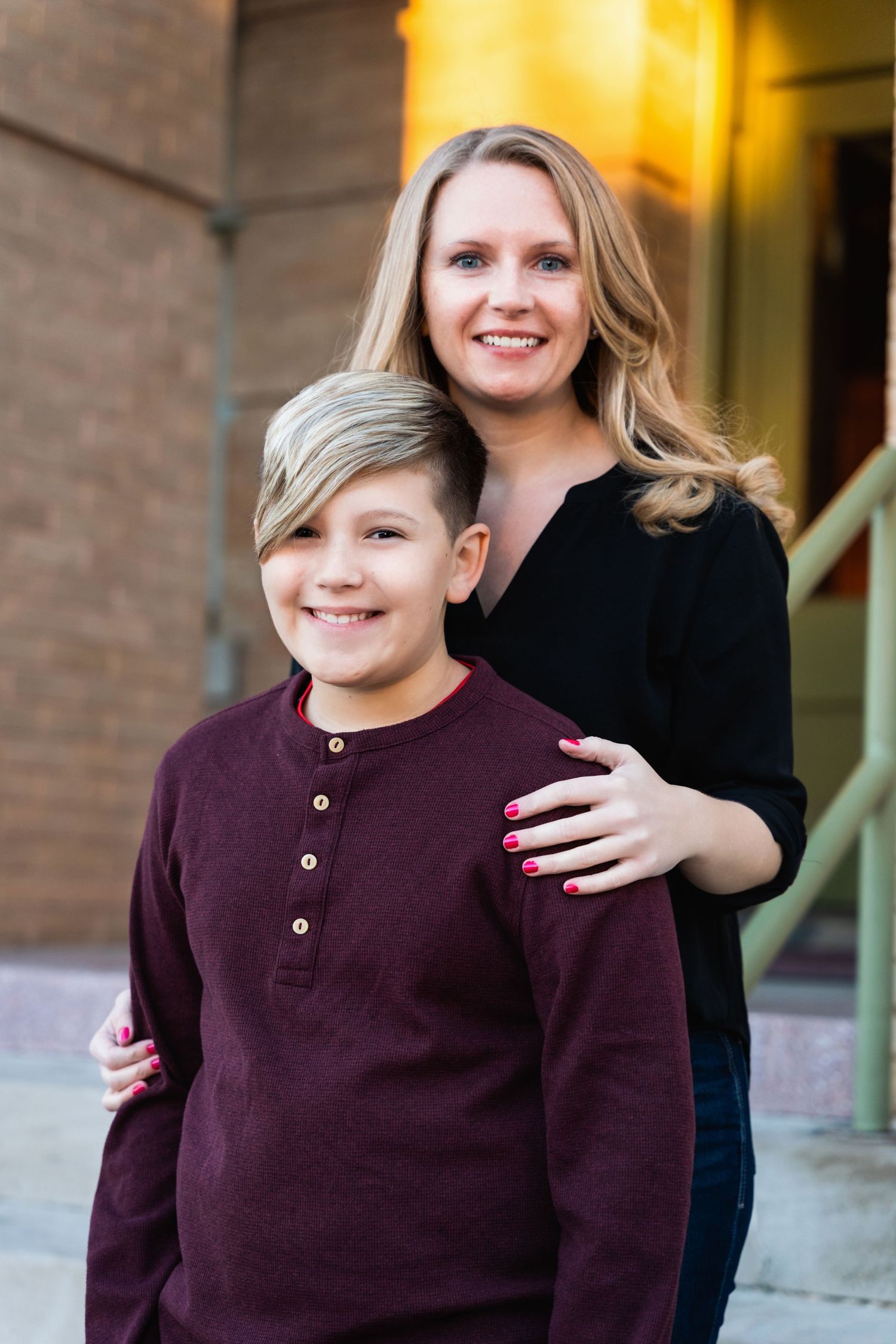 Parent and child posing together outdoors wearing matching dark tops.