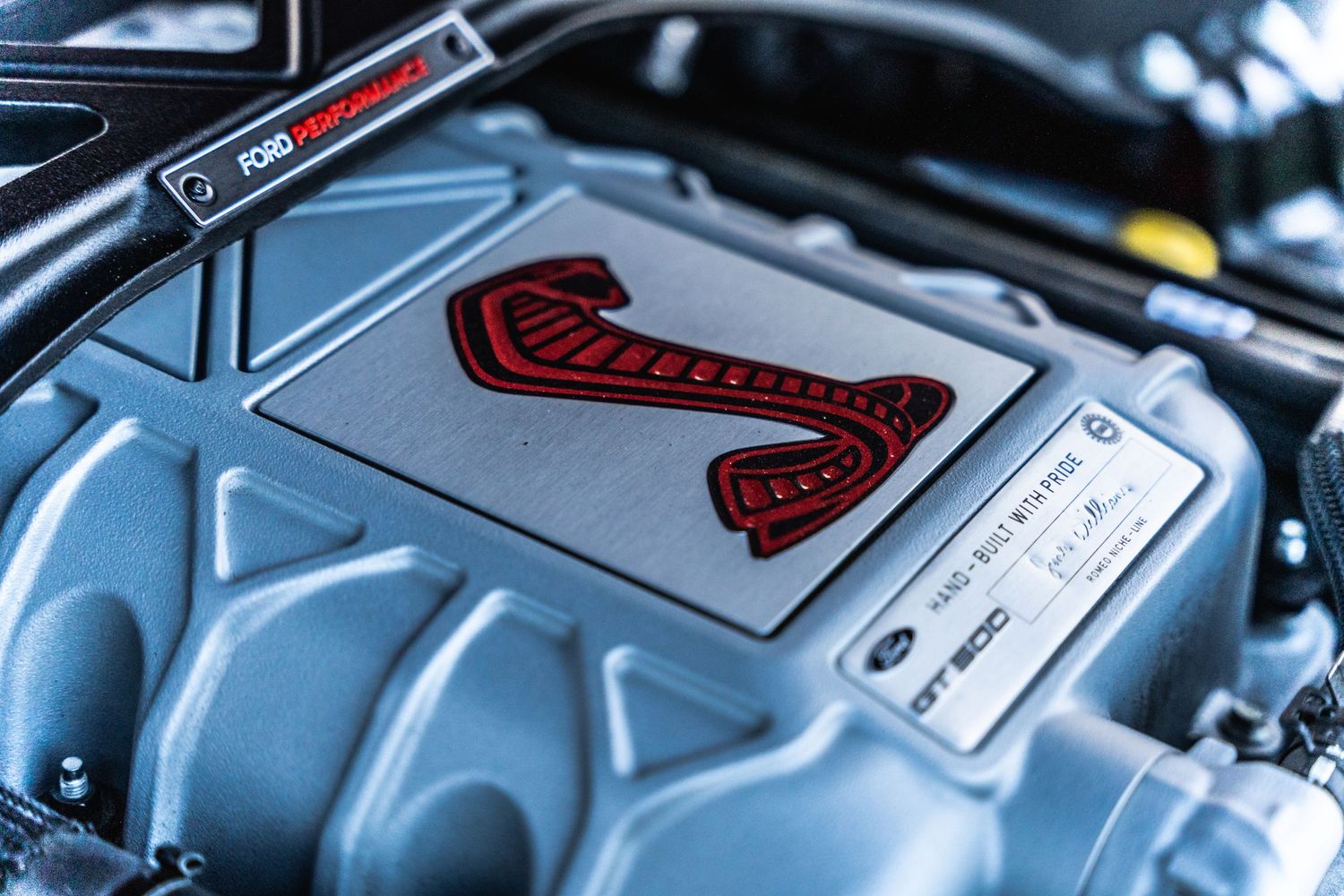 Close-up of a Cobra engine cover in a performance vehicle.