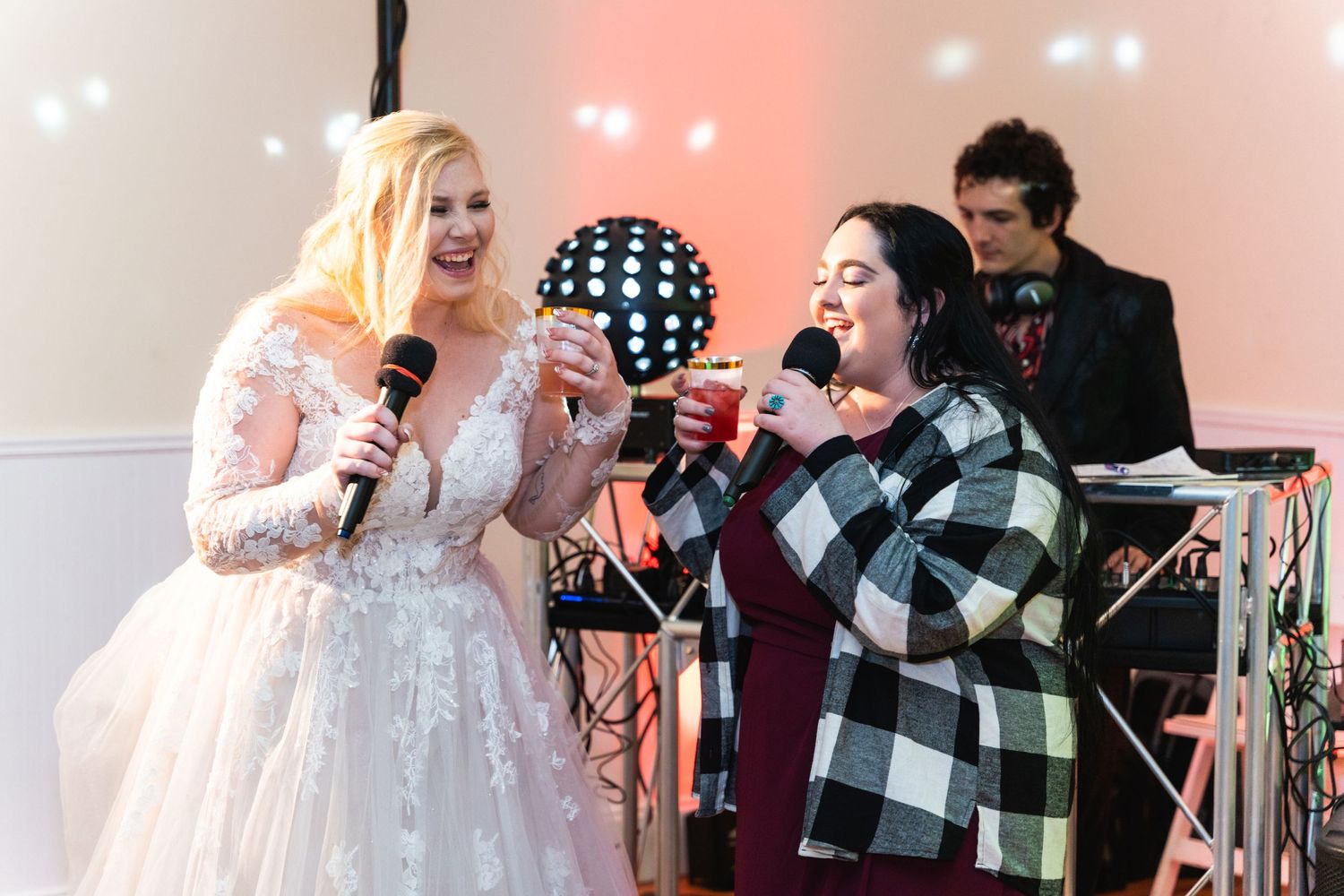 Wedding celebration features duet singing performance with disco ball and stage lighting in the background.