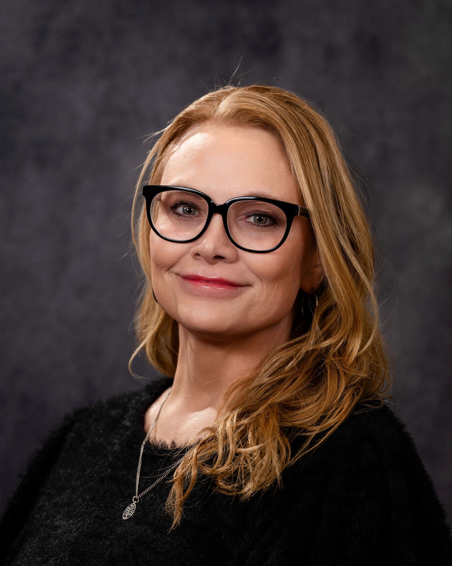 Series of portrait shots with black sweater and glasses against dark studio backdrop.