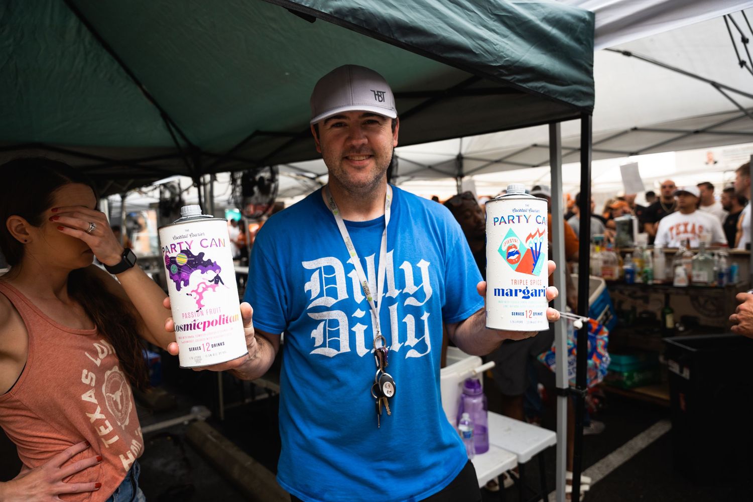 Vendor displaying canned beverages at an outdoor festival booth.