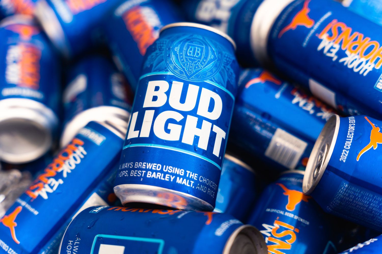 Multiple blue aluminum Bud Light beer cans stacked together in a pile.