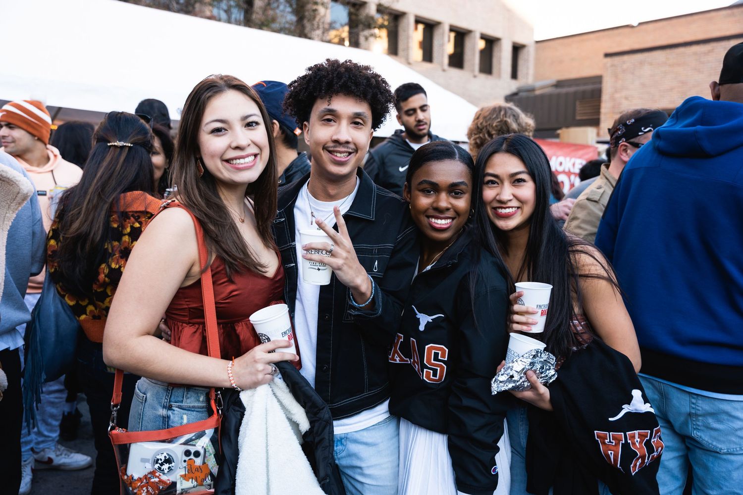 Young people smiling and posing together at an outdoor sports event.