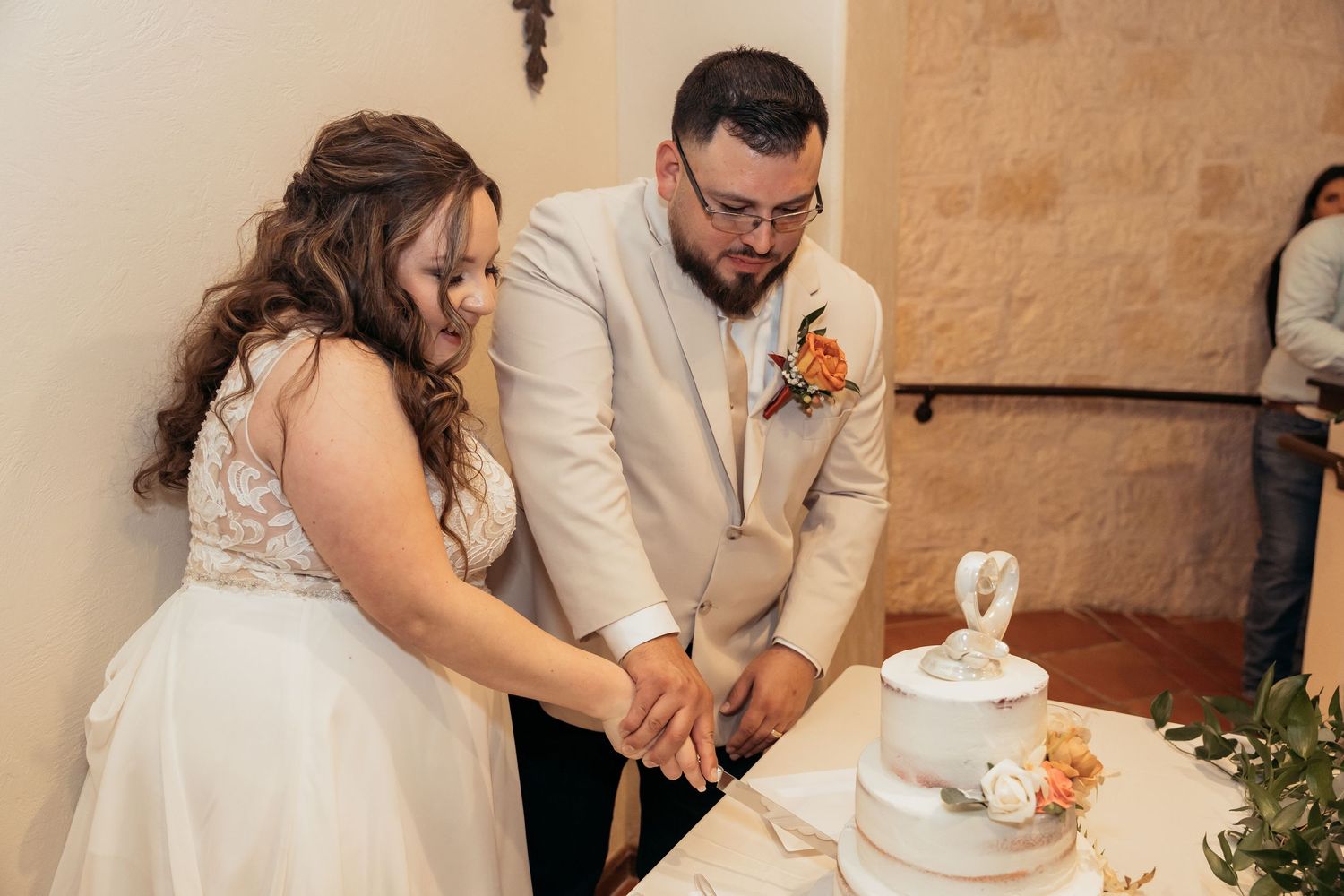 Couple performs traditional cake cutting ceremony at their wedding reception.