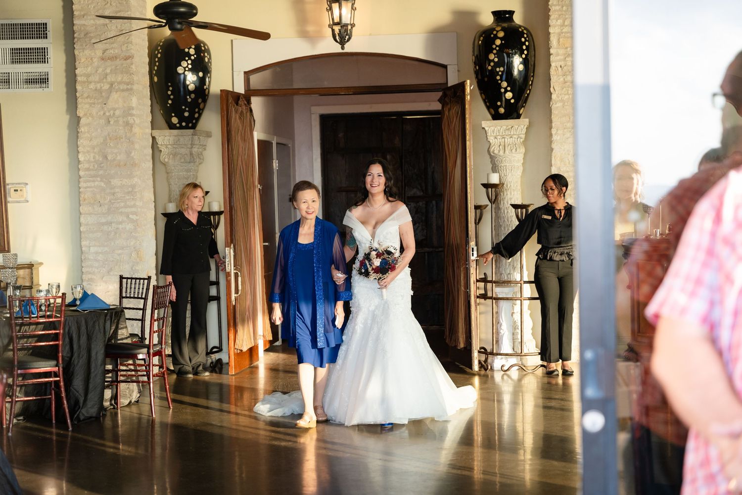 A wedding party entrance at an elegant venue with decorative vases and archways.