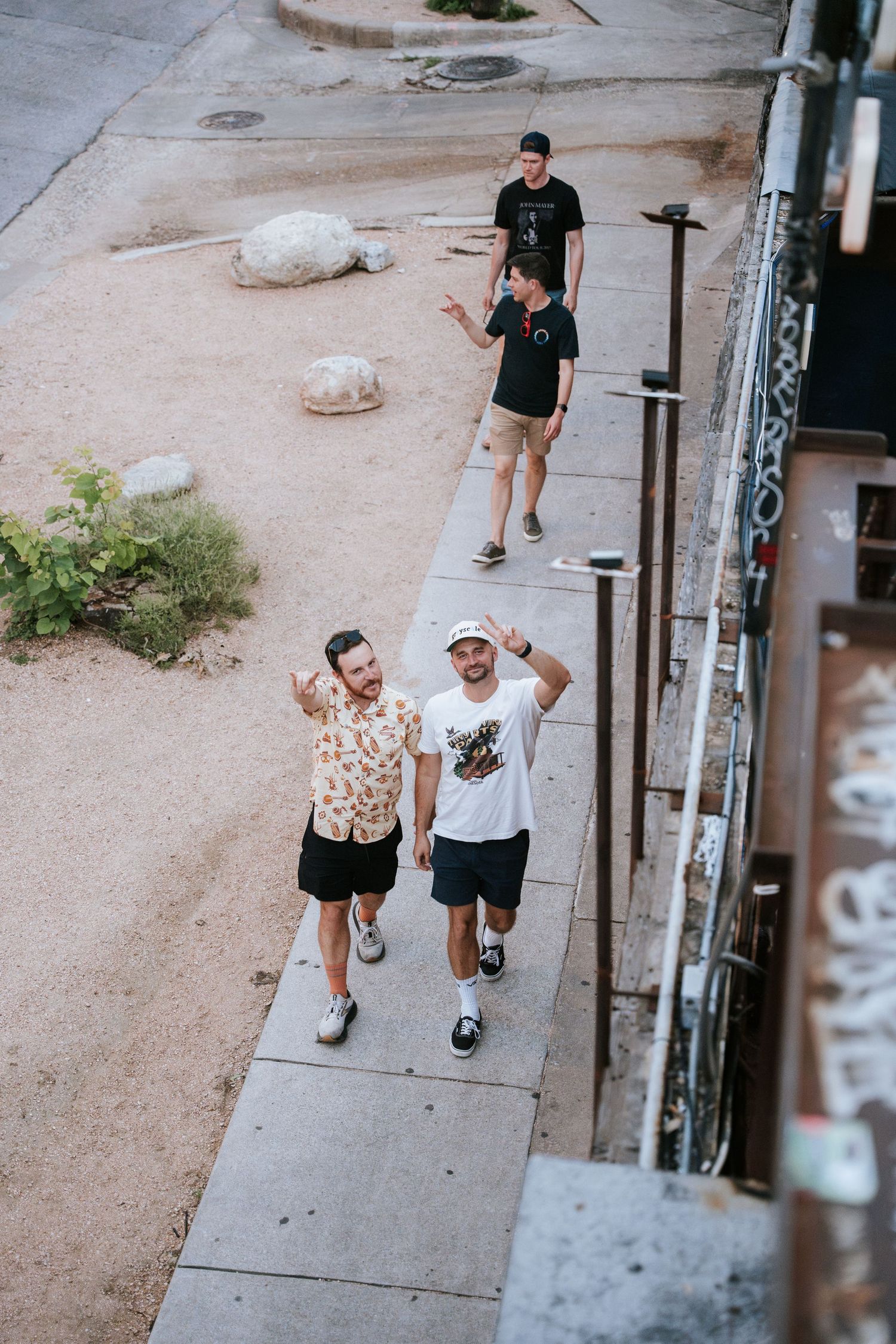 Aerial view of people walking on a sidewalk next to industrial building.