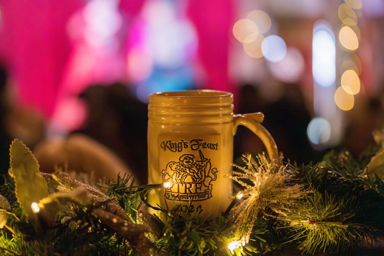 Illuminated glass mason jar decoration with greenery and holiday lights creating a warm glow.