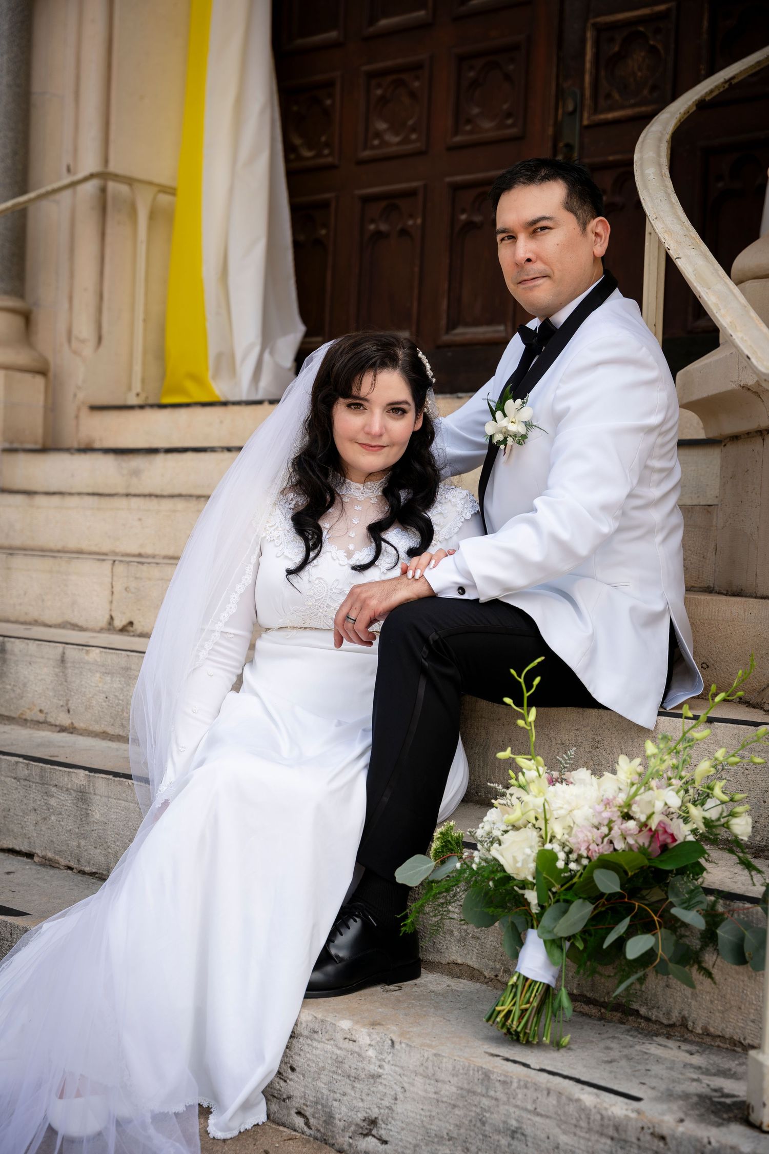 A series of five romantic wedding photos shows a couple in black and white attire posing on stone steps with flowers.