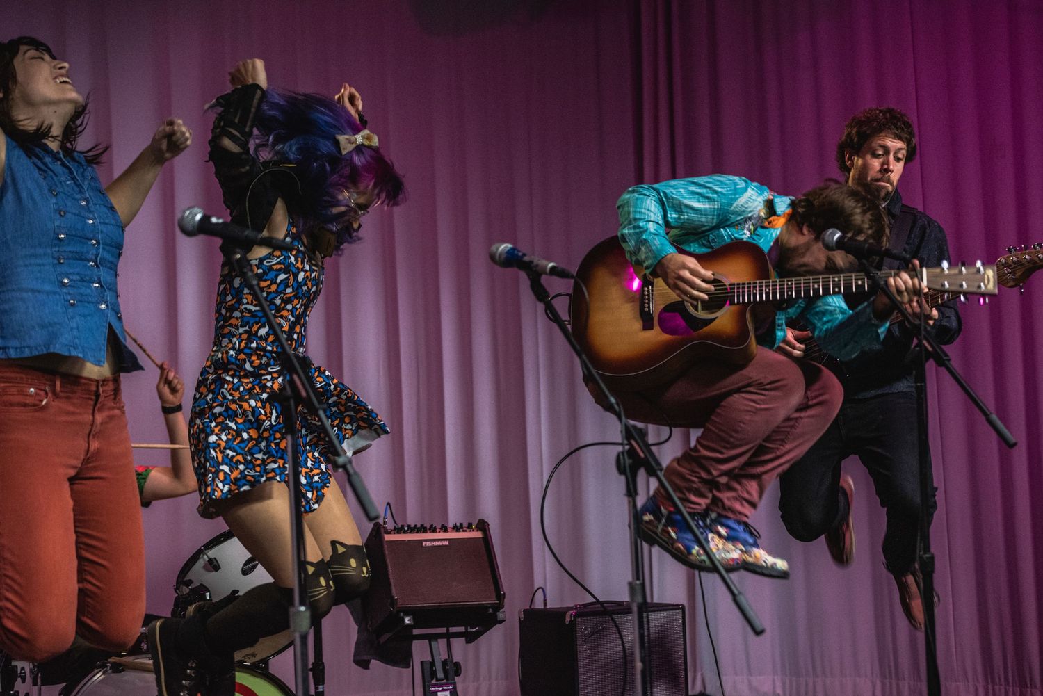 Musicians perform with acoustic guitar and other instruments during live concert.
