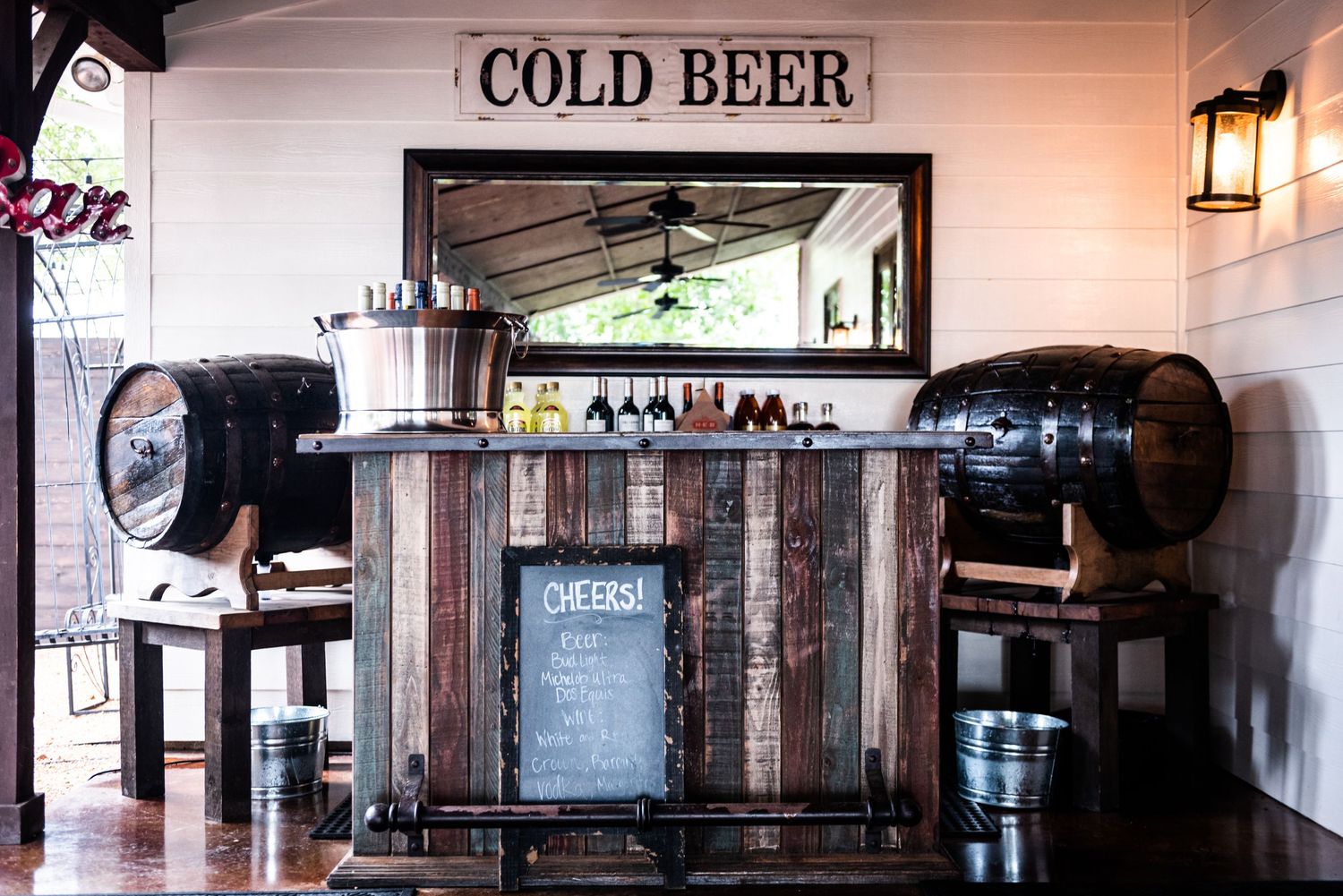 Rustic wooden bar setup with COLD BEER sign and barrel decor.