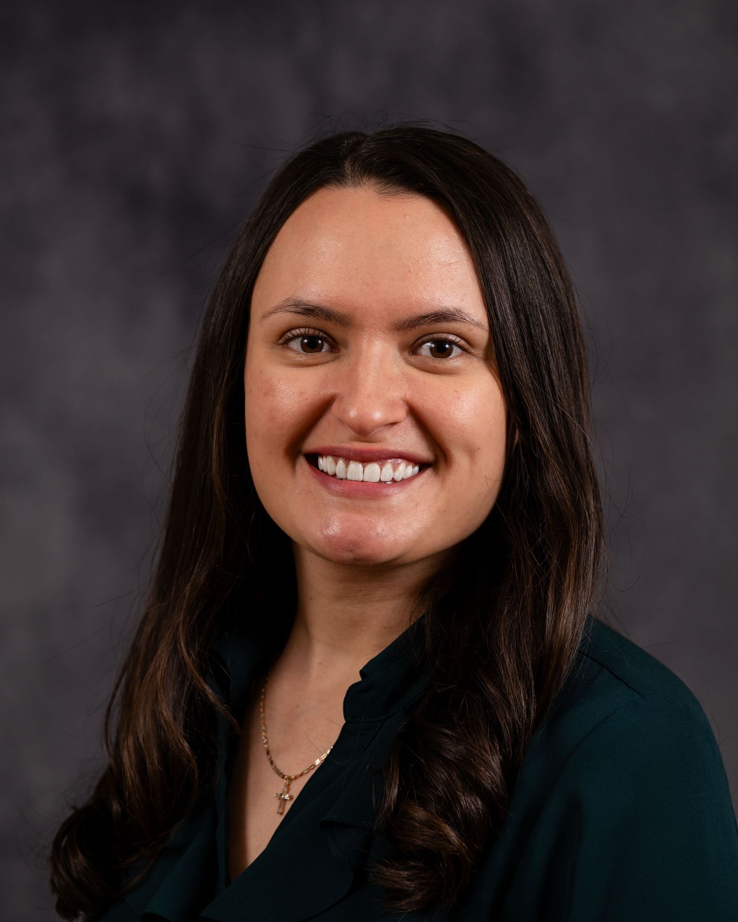 A sequence of professional headshots showing a person in a dark blazer against a gray background, smiling warmly.