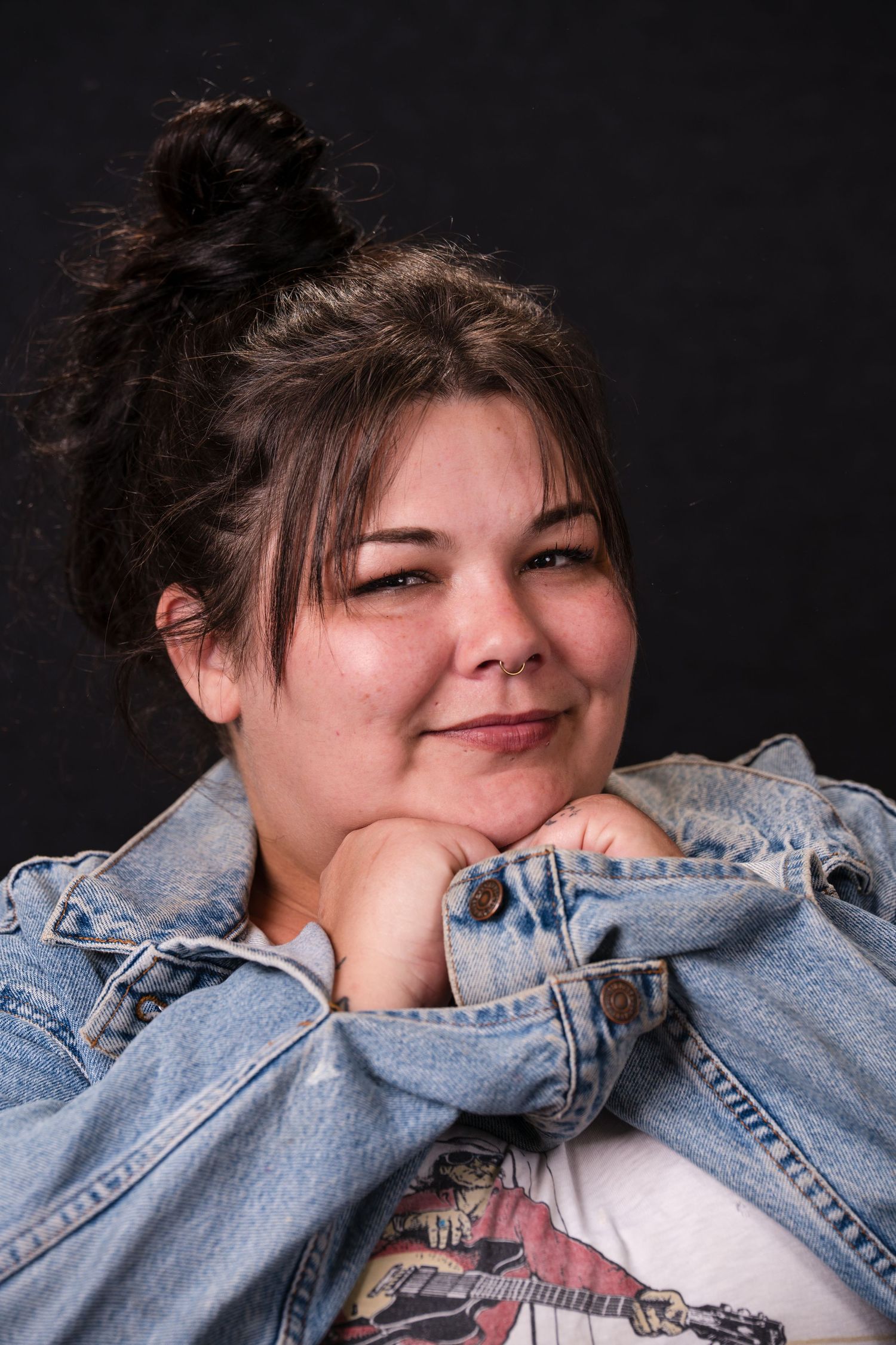A playful portrait series against a dark background showing someone wearing a denim jacket and making expressive poses.