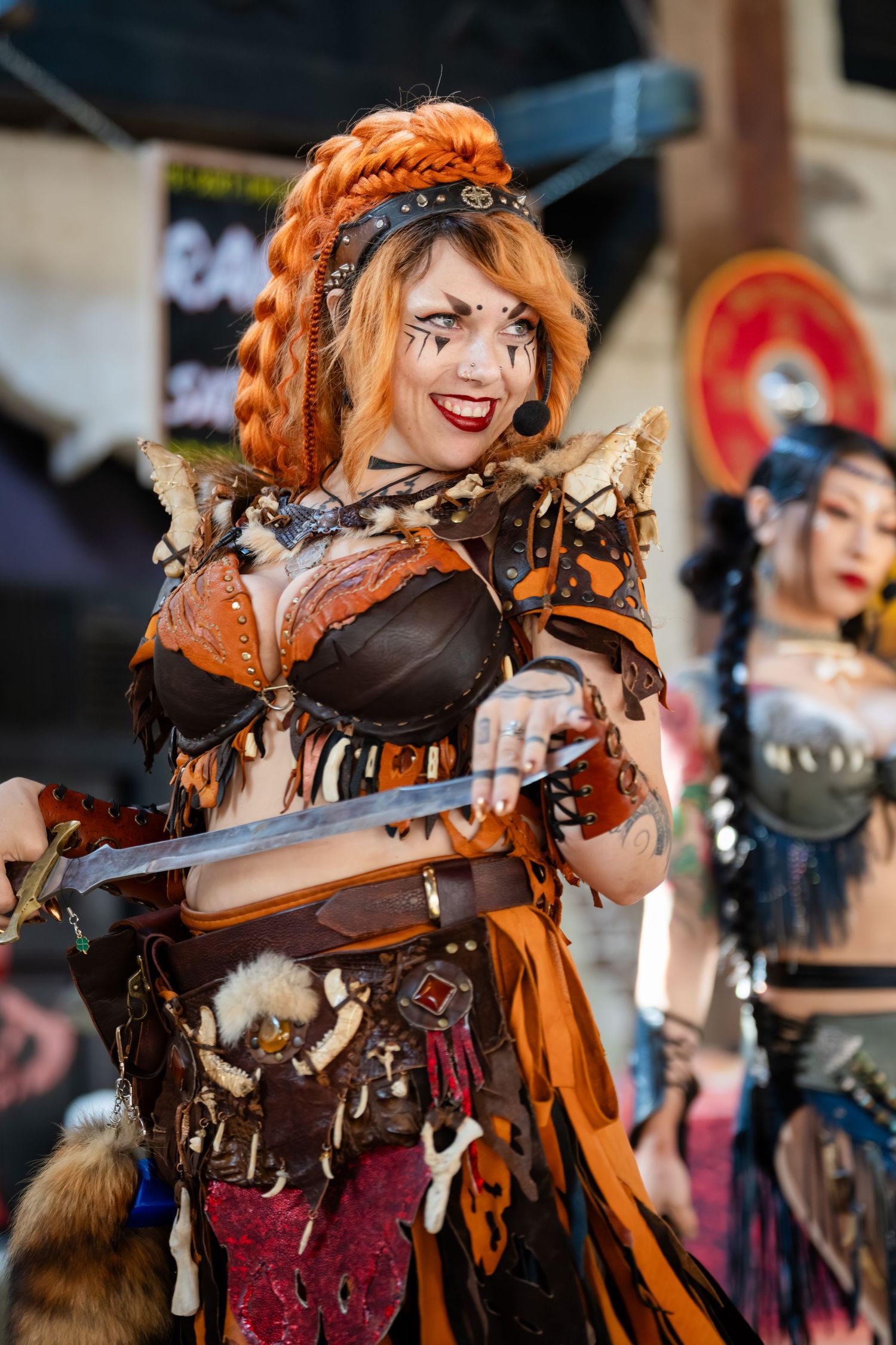 Cosplayer in detailed orange and brown steampunk costume with ornate accessories at a convention.