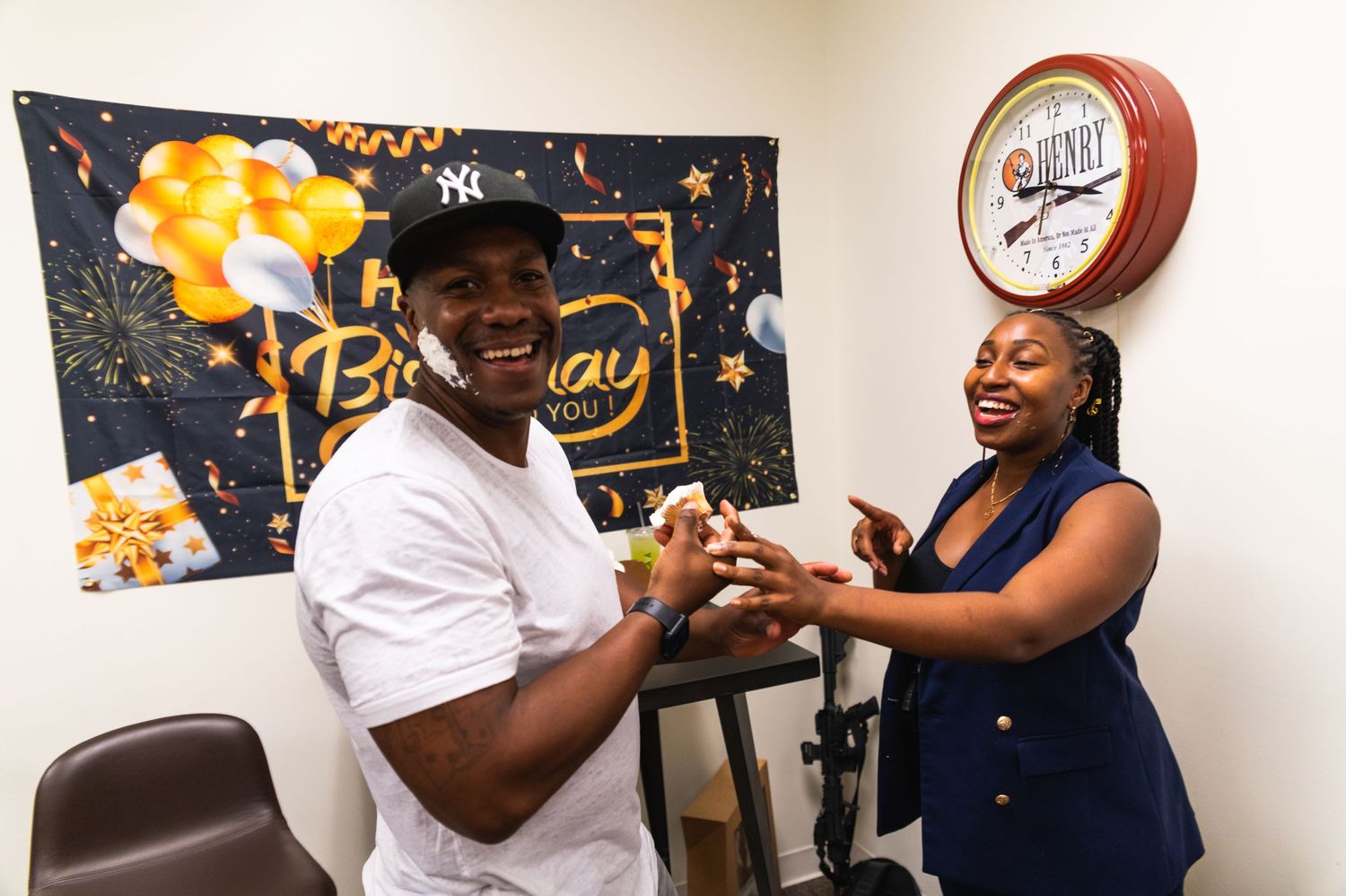 Celebratory moment between two people with birthday decorations in background.