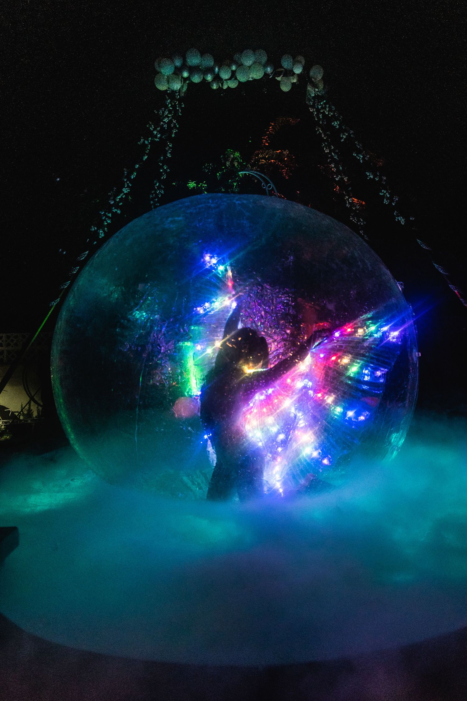 Colorful LED lights create a mesmerizing display inside a large bubble sphere with fog effects.