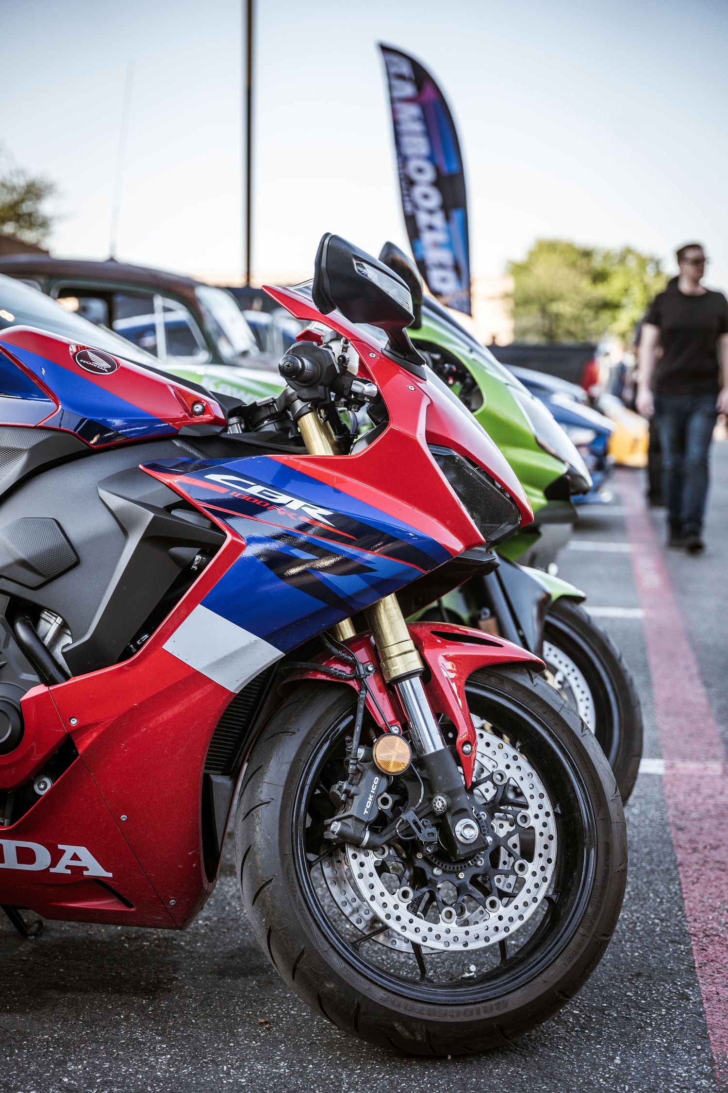 Red and blue Honda CBR sport motorcycle on display at an outdoor car meet.
