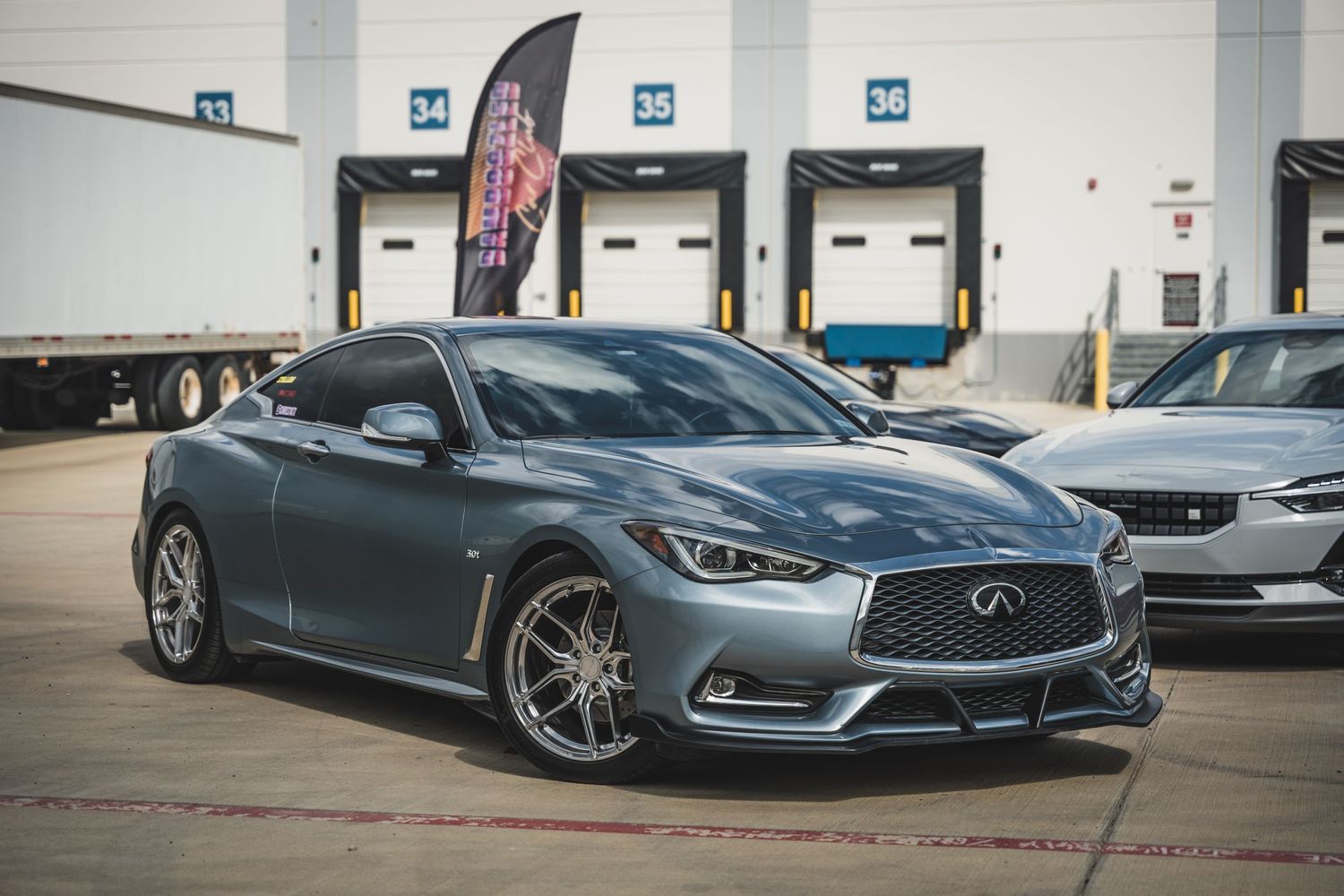 Modified Infiniti Q60 coupe in metallic grey showcasing custom wheels and body styling.