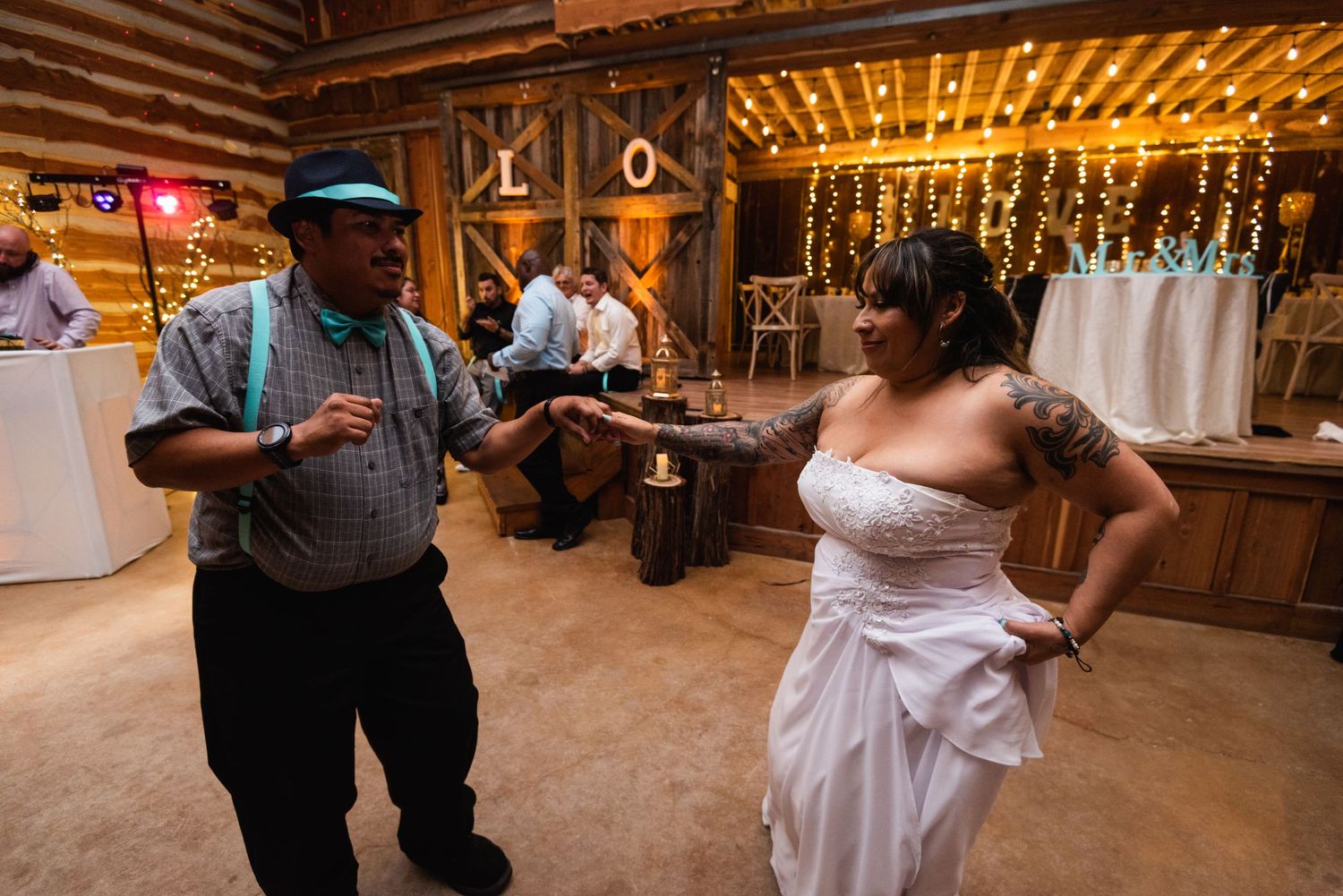 Guests dancing and enjoying themselves at a rustic barn wedding reception.