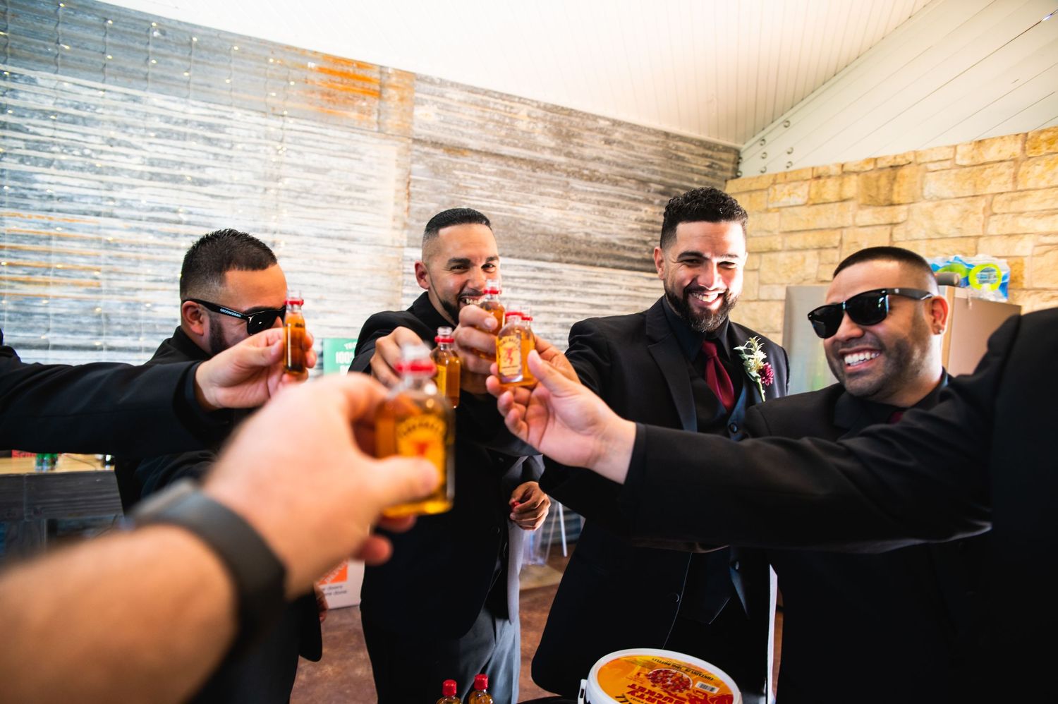 A group raises glasses in a celebratory toast at an indoor gathering.