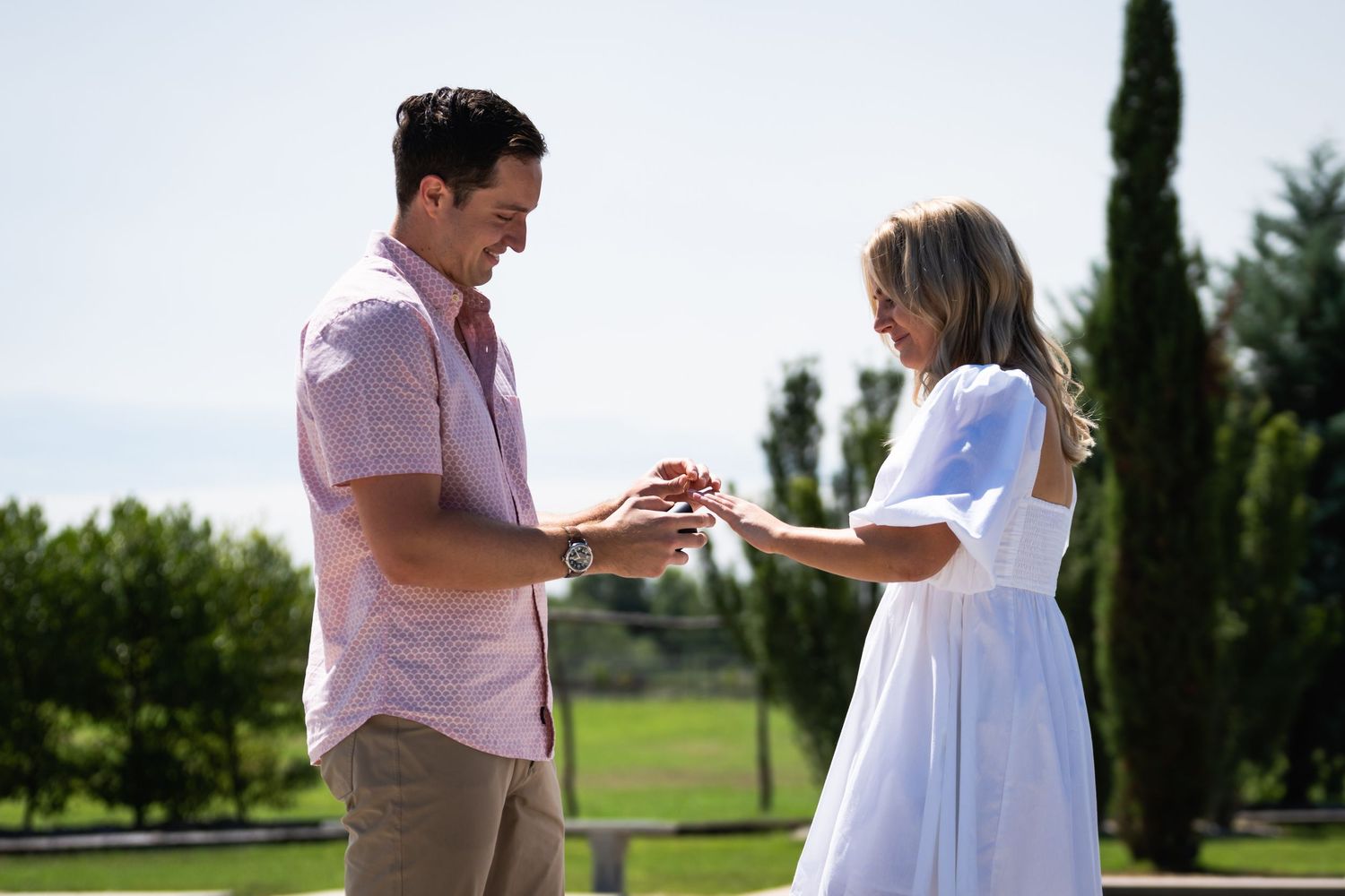 A couple shares a tender moment during their engagement by a fountain.