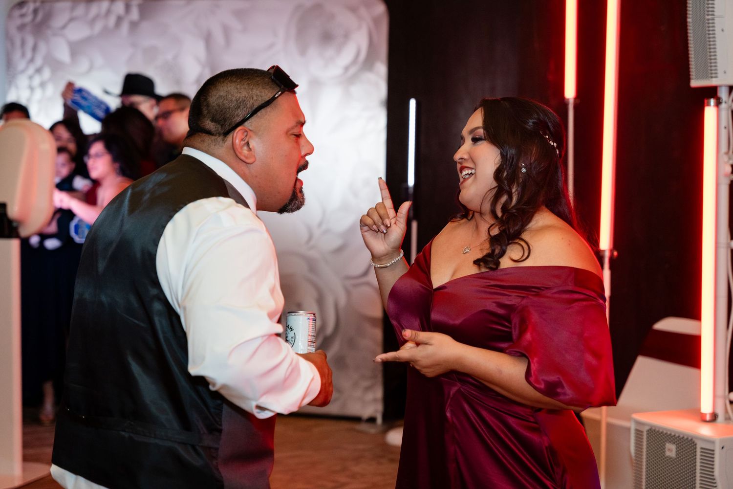 Wedding guests enjoying conversation and laughter during an evening reception celebration.