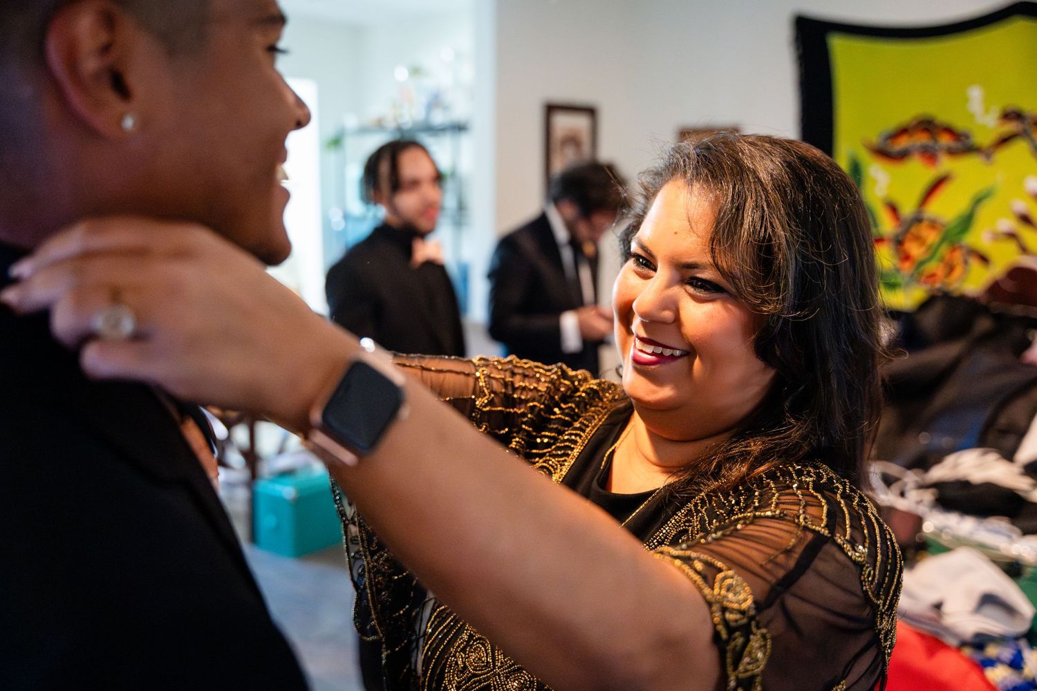 Candid moment during wedding preparations shows joyful interaction in indoor setting.