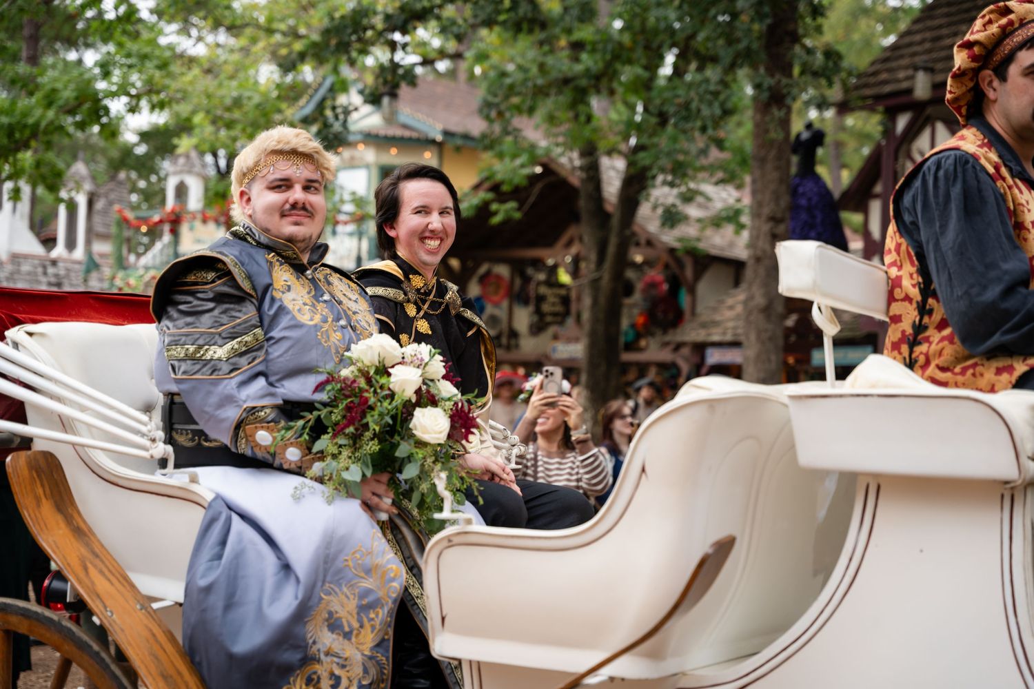 Wedding party rides in a classic white vintage car during an outdoor celebration.