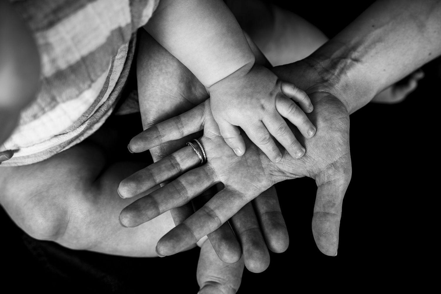 A series of black and white photographs showing close-up shots of hands reaching and touching in various positions.