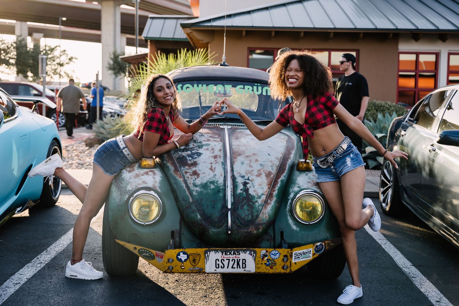 Classic vintage Volkswagen Beetle parked at a car show with colorful decorations.