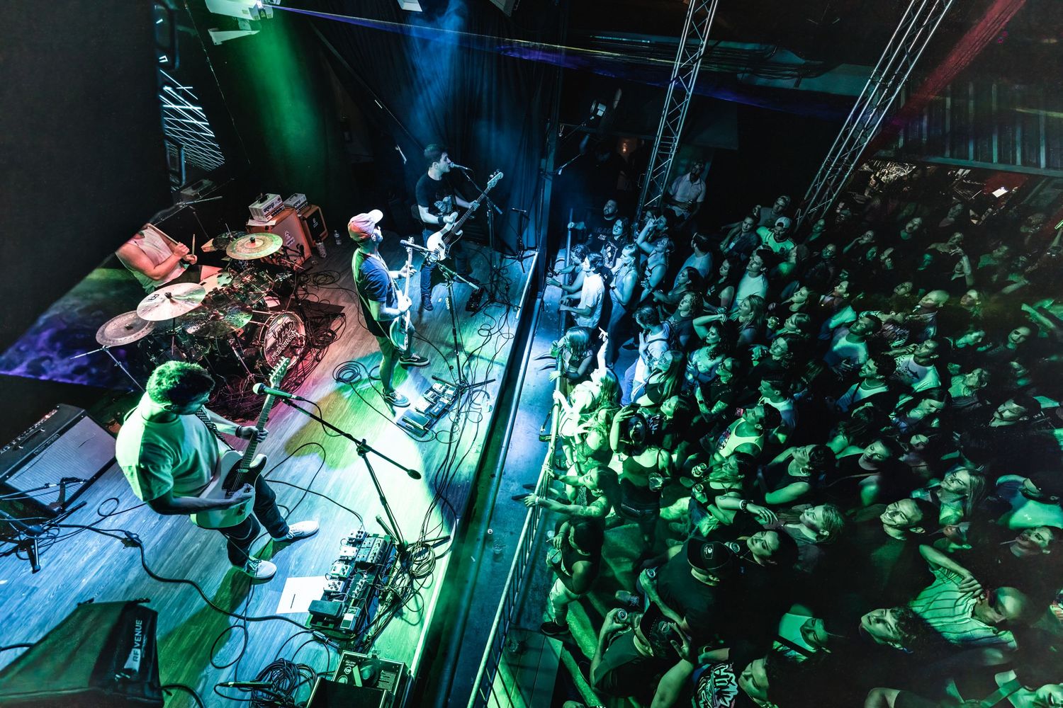 Band performs energetic show with crowd visible from elevated stage perspective.